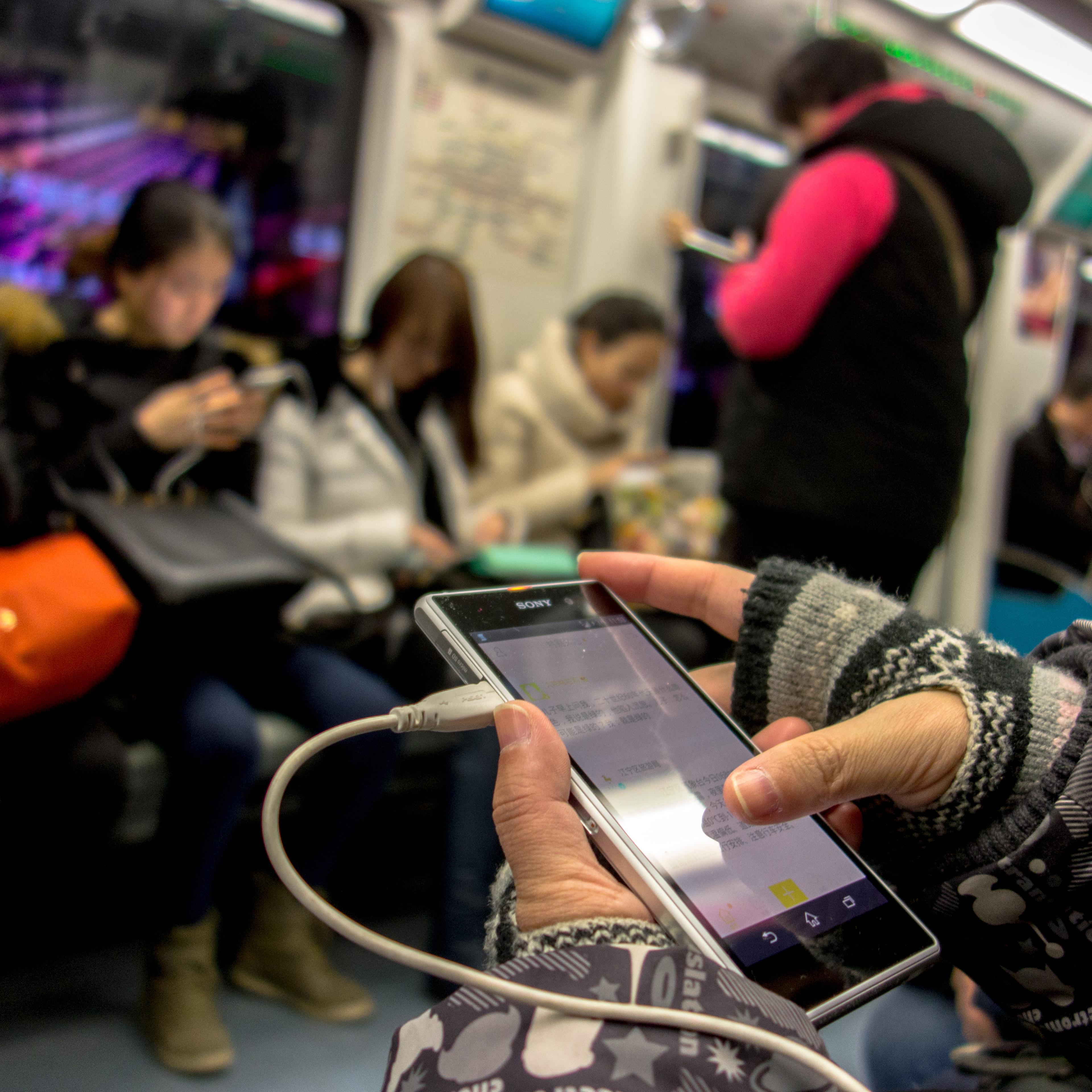 Passengers reads news or watch videos on their smart phones