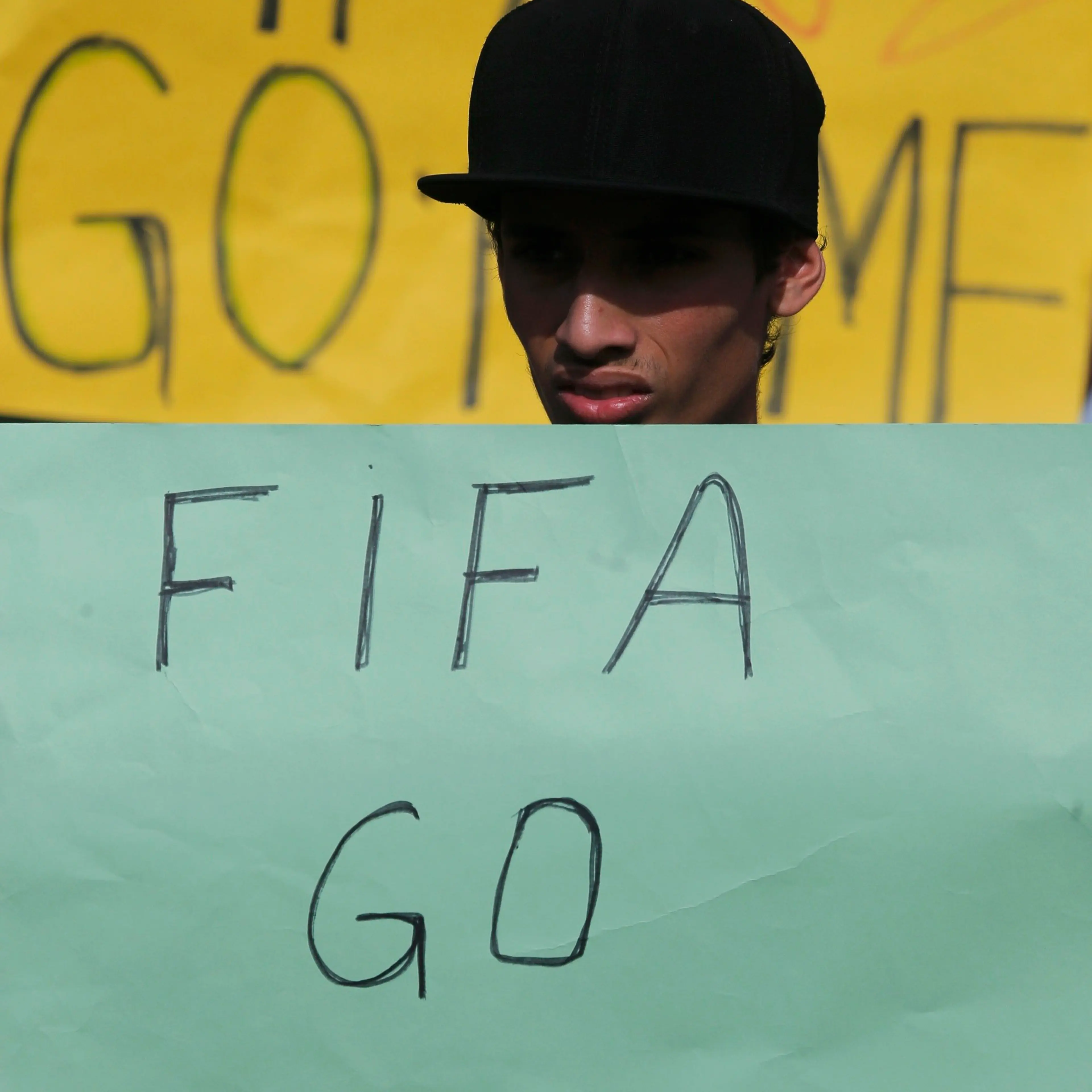 An activist holds a protest poster in front of the municipal stadium prior to a training session by Japan's national soccer in Sorocaba