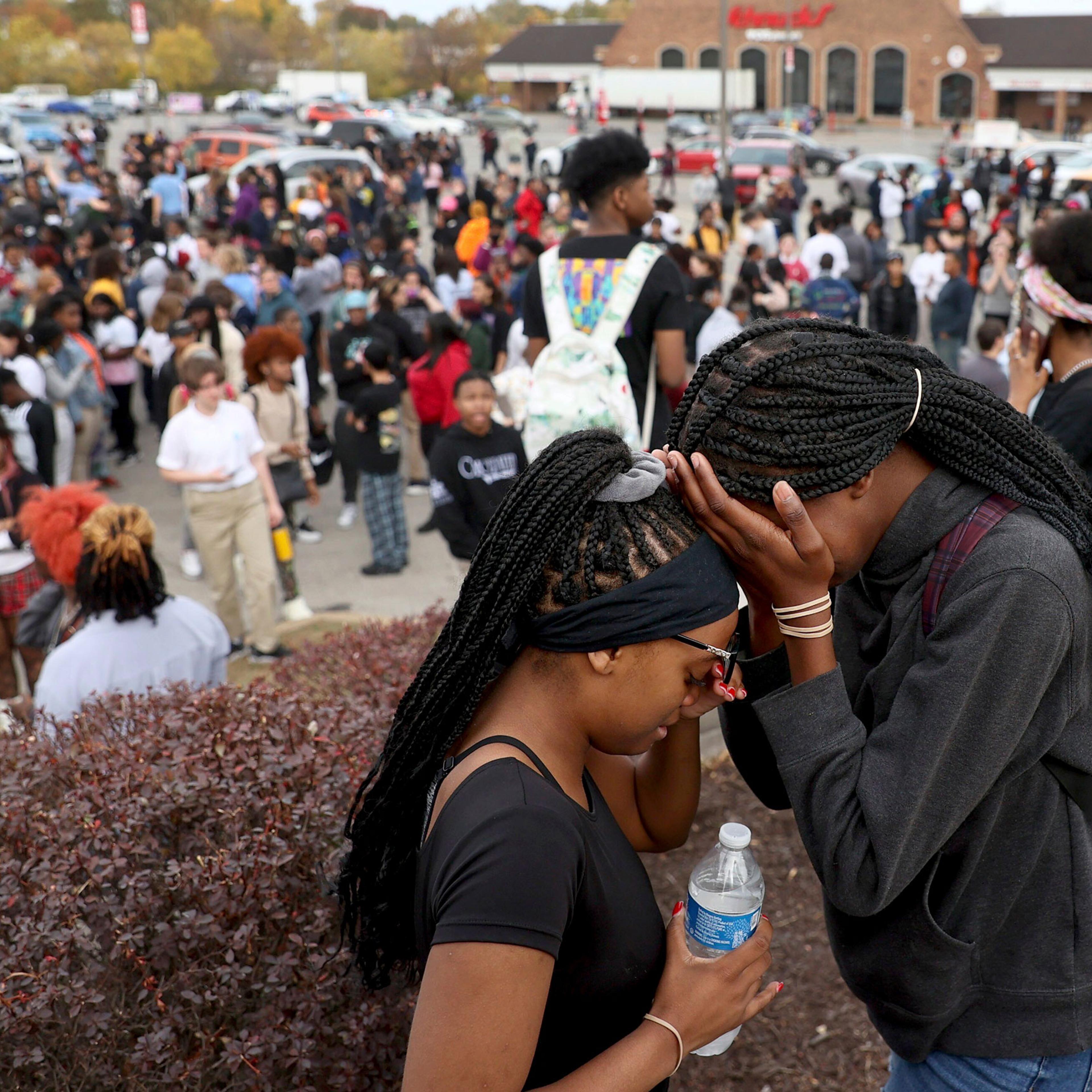 Students stand in a parking lot near the Central Visual & Performing Arts High School after a reported shooting at the school in St. Louis, on Monday, Oct. 24, 2022.