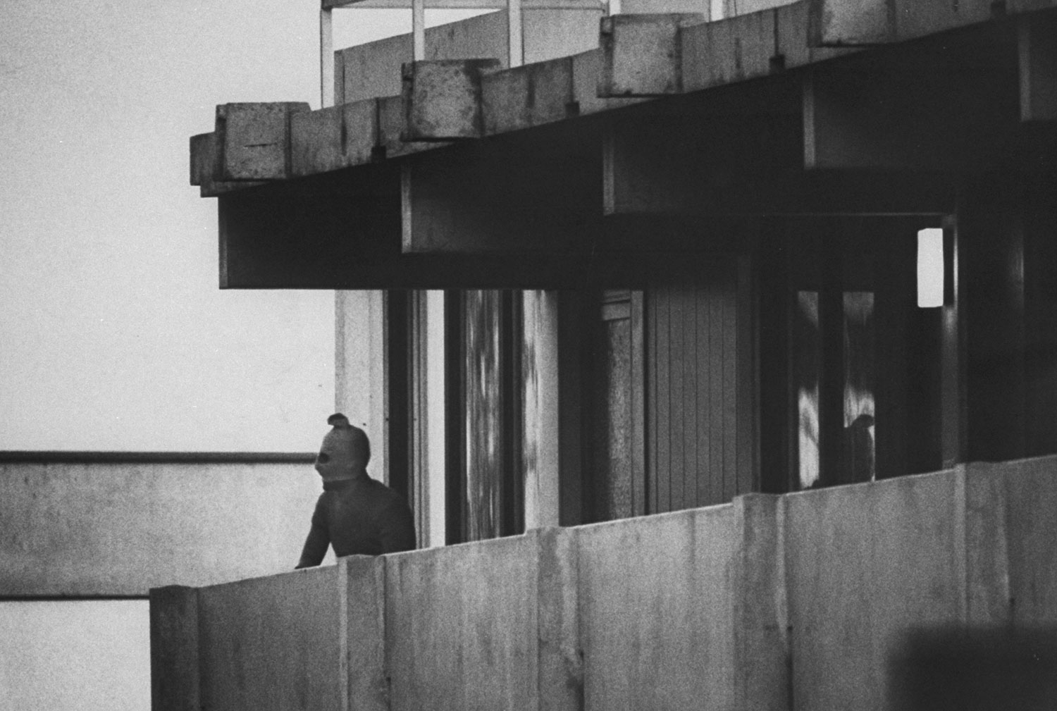 A Black September terrorist looks from the balcony of an apartment where Israeli Olympic team members are held hostage, Munich, September 1972.