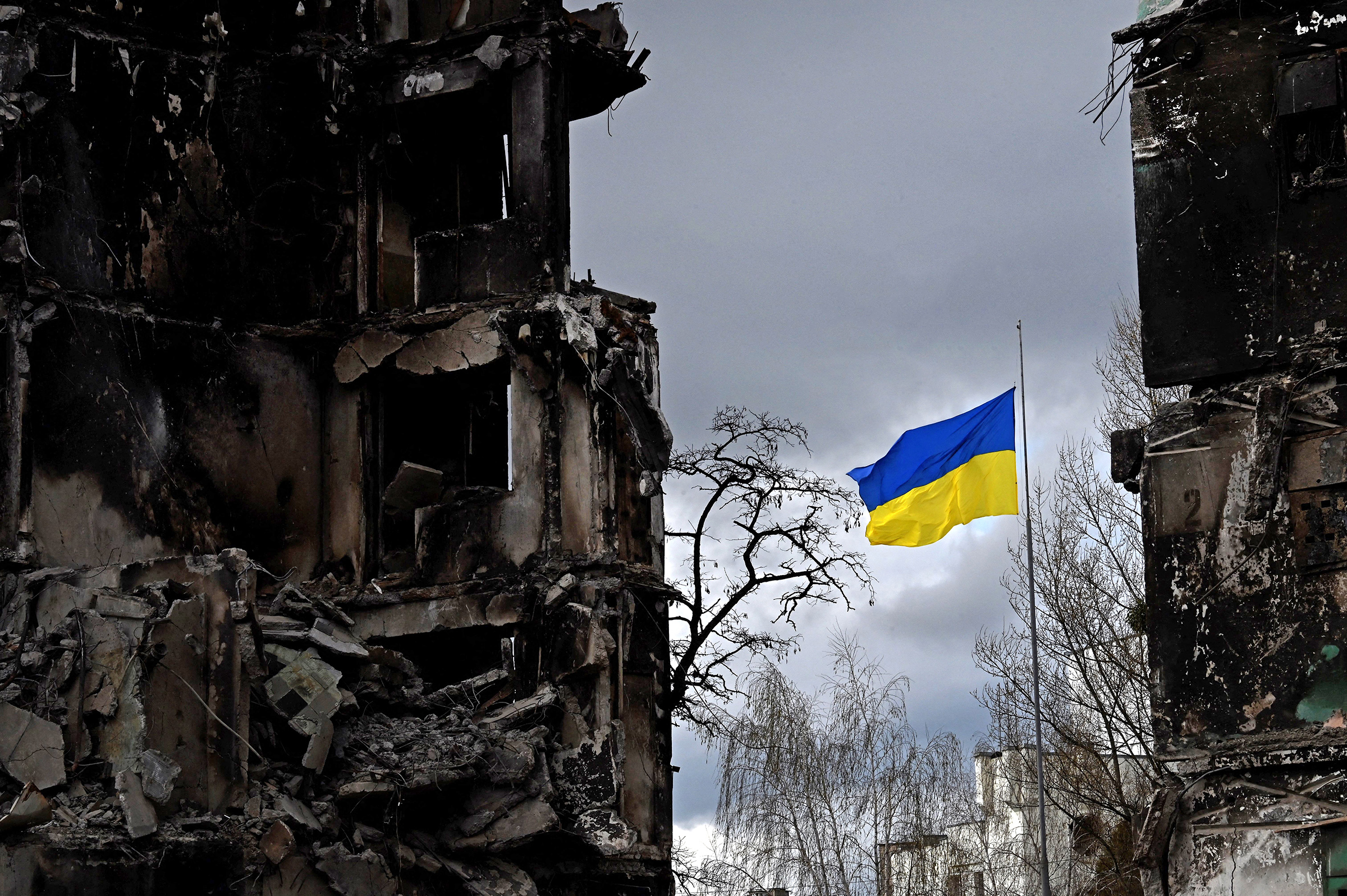 The Ukrainian flag flutters between buildings destroyed in bombardment, in the Ukrainian town of Borodianka, in the Kyiv region on April 17, 2022.