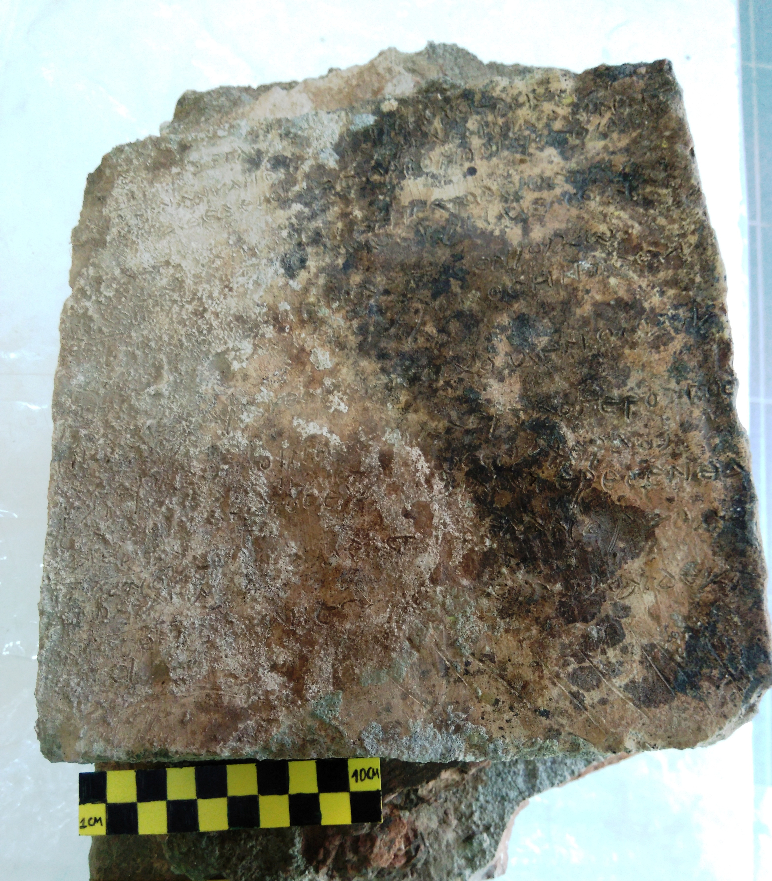 Picture of a clay plaque with an engraved inscription depicting thirteen verses from the Odyssey's 14th Rhapsody
