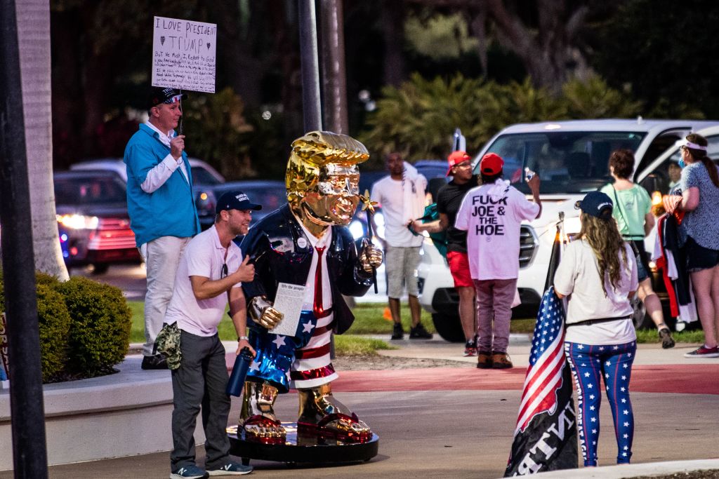 Supporters of former US President Donald Trump take pictures with a gold statue of him outside the hotel where the Conservative Political Action Conference 2021 (CPAC) is being held in Orlando, Florida on February 28, 2021.