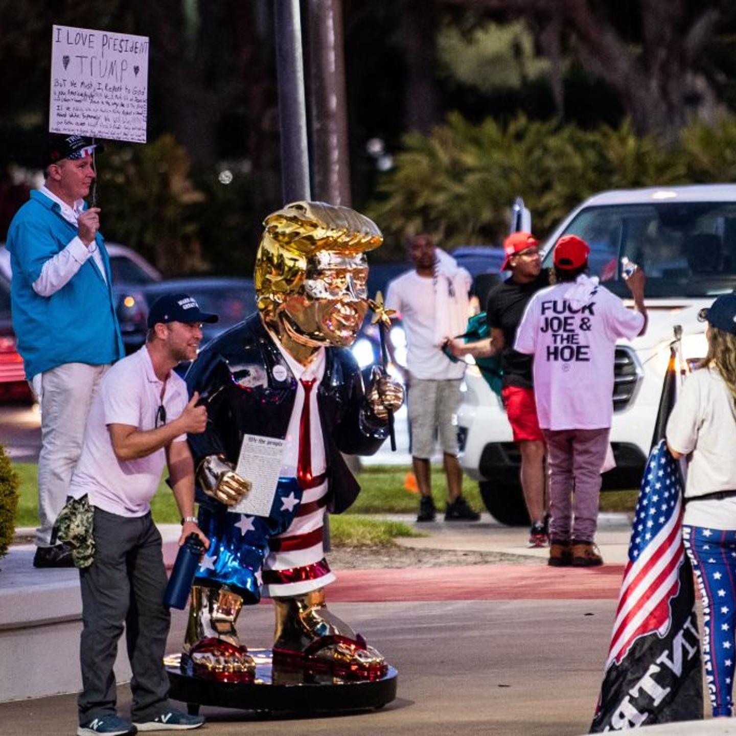 Supporters of former US President Donald Trump take pictures with a gold statue of him outside the hotel where the Conservative Political Action Conference 2021 (CPAC) is being held in Orlando, Florida on February 28, 2021.