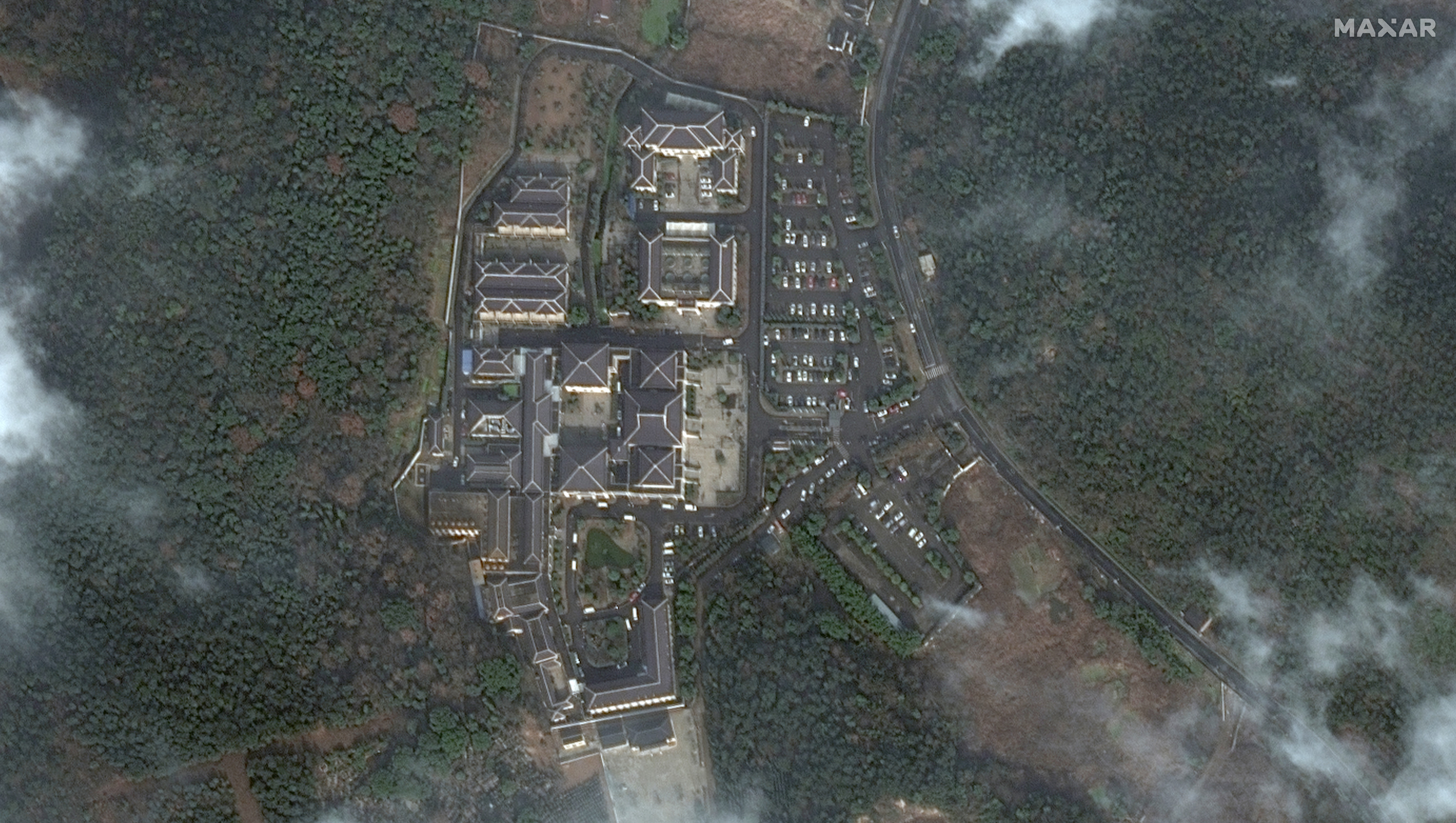 A satellite image taken on Jan. 3, 2022, shows a funeral home in Huzhou with a packed parking lot. An image taken in January of last year features far fewer cars.