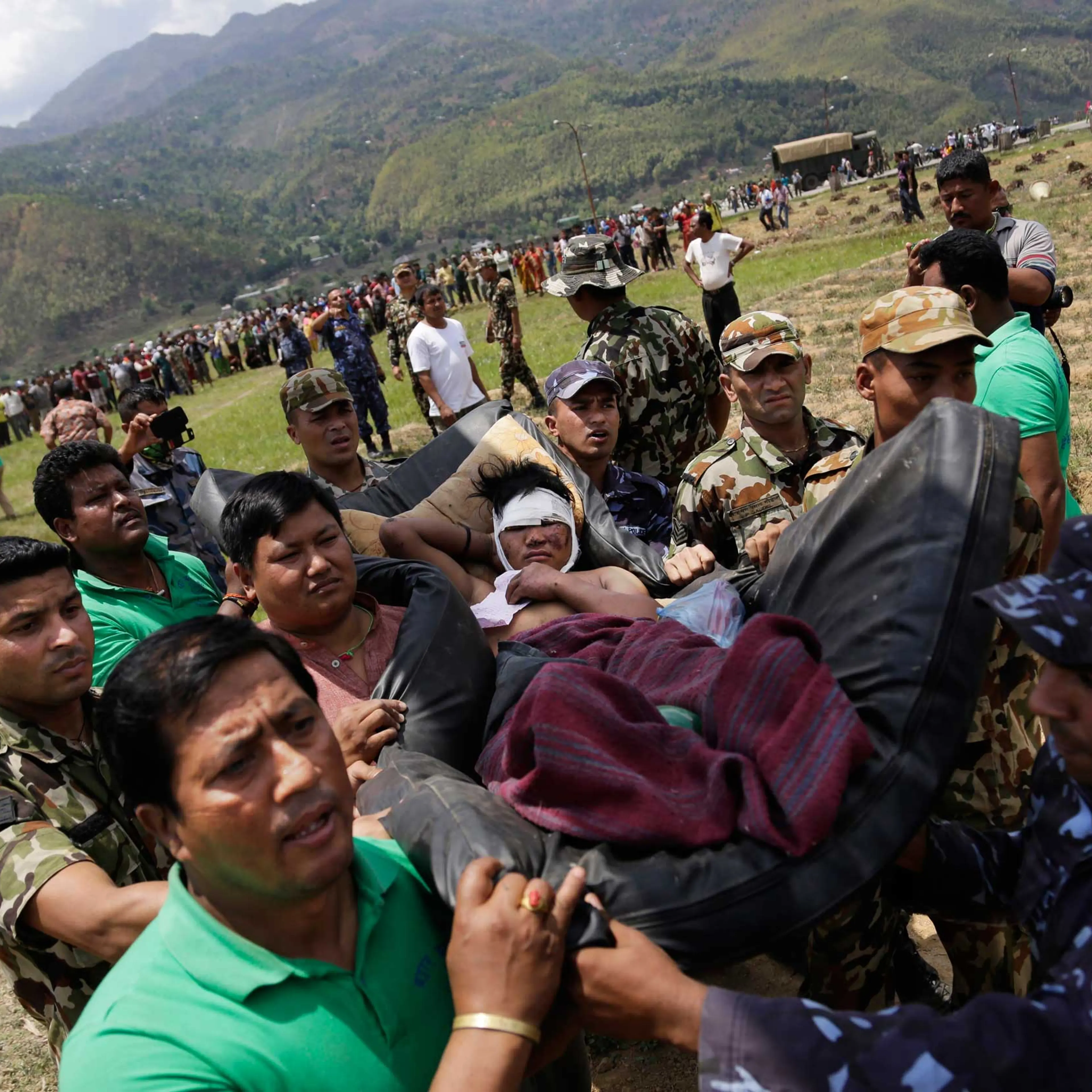 Nepalese soldiers carry a wounded man on a makeshift stretcher to an Indian Air Force helicopter as they evacuate victims of Saturday's earthquake from Trishuli Bazar to Kathmandu airport in Nepal on April 27, 2015.