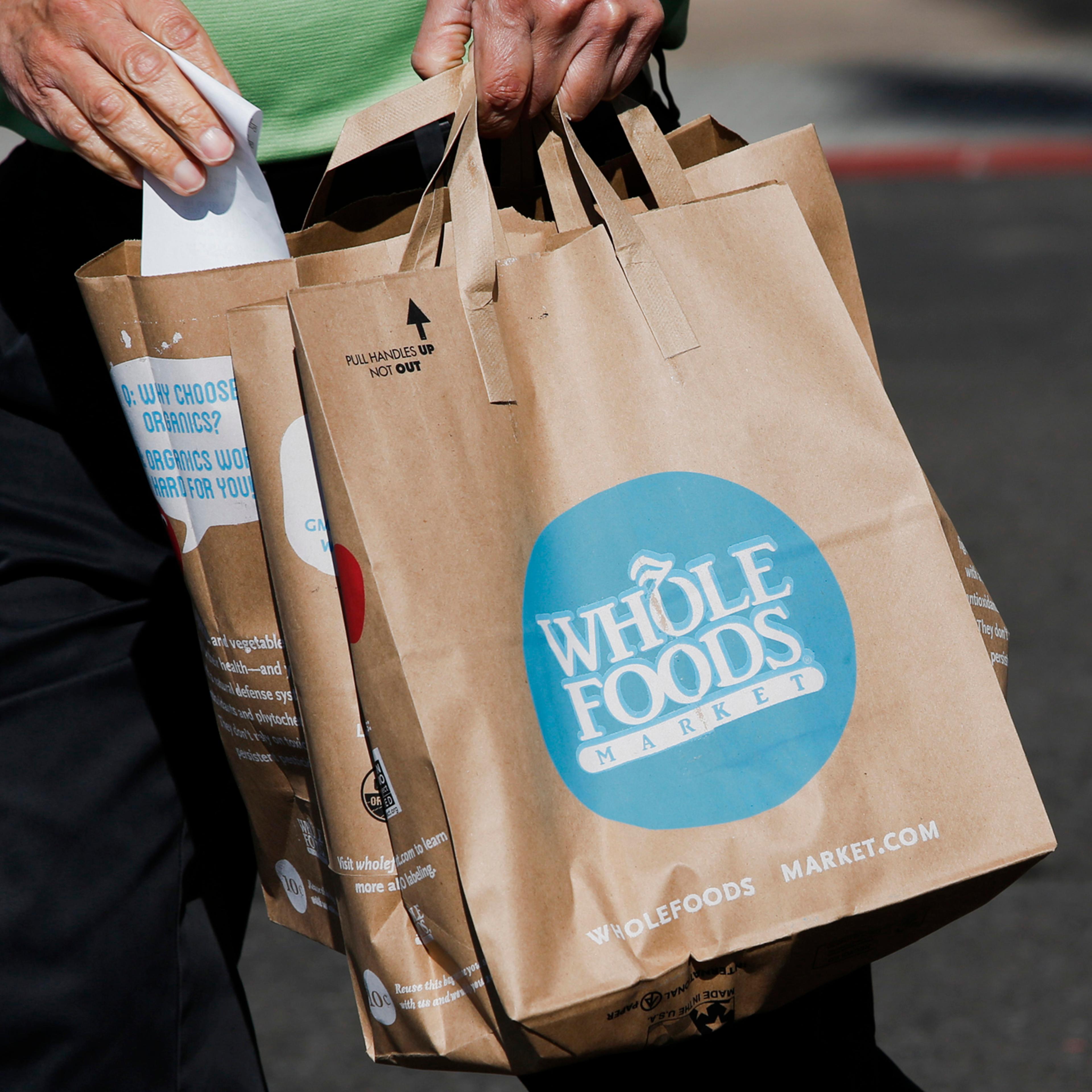 A customer carries shopping bags outside of a Whole Foods in El Segundo, Calif., Nov. 5, 2013.