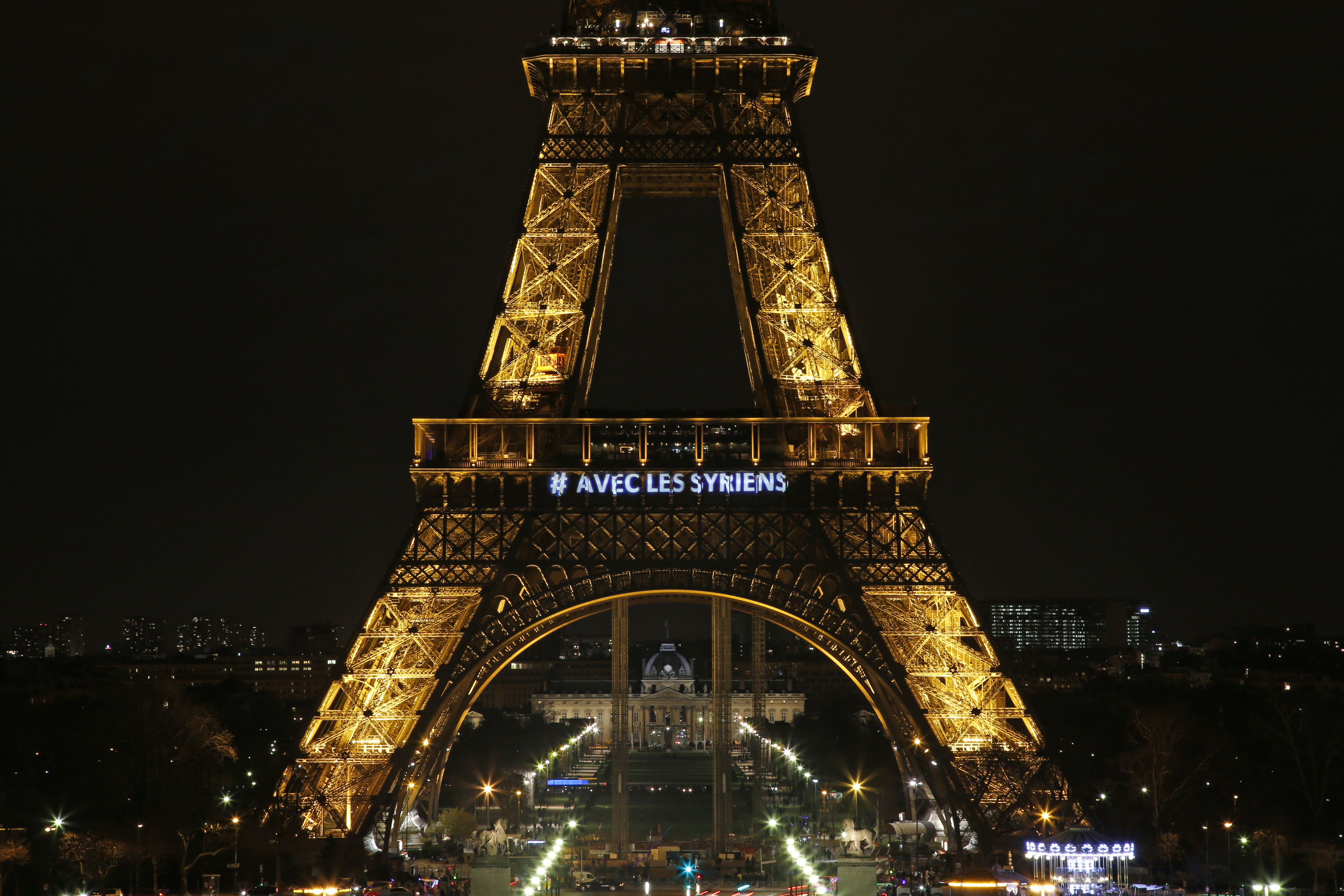 The words "With the Syrians" are displayed on the Eiffel Tower in support of Syrians on the third anniversary of the conflict, in Paris