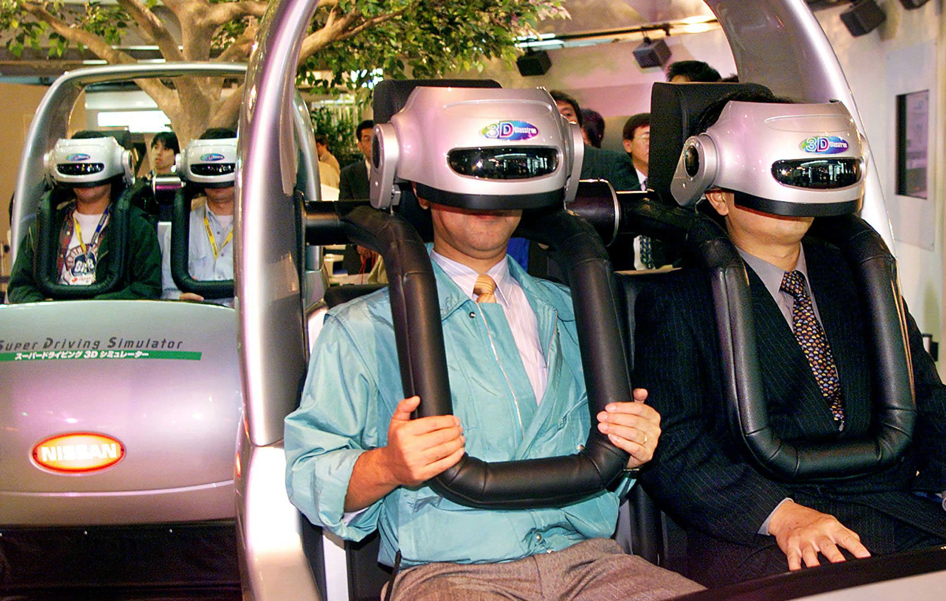Visitors enjoy virtual reality driving with 3-D goggles and driving simulators for the presentation of Japan's automaker Nissan at the Tokyo Motor Show in Tokyo.