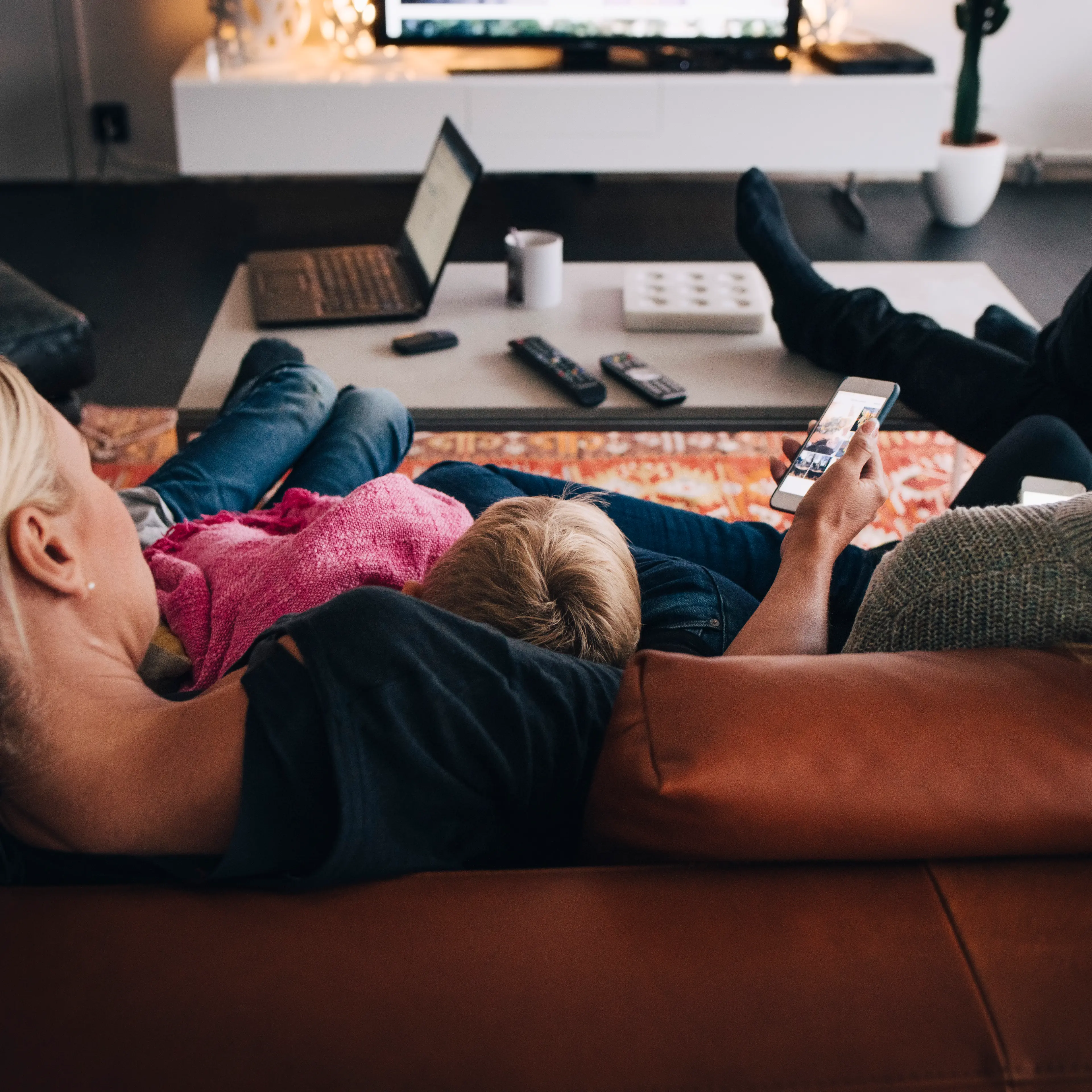 Rear view of family sitting on sofa at home