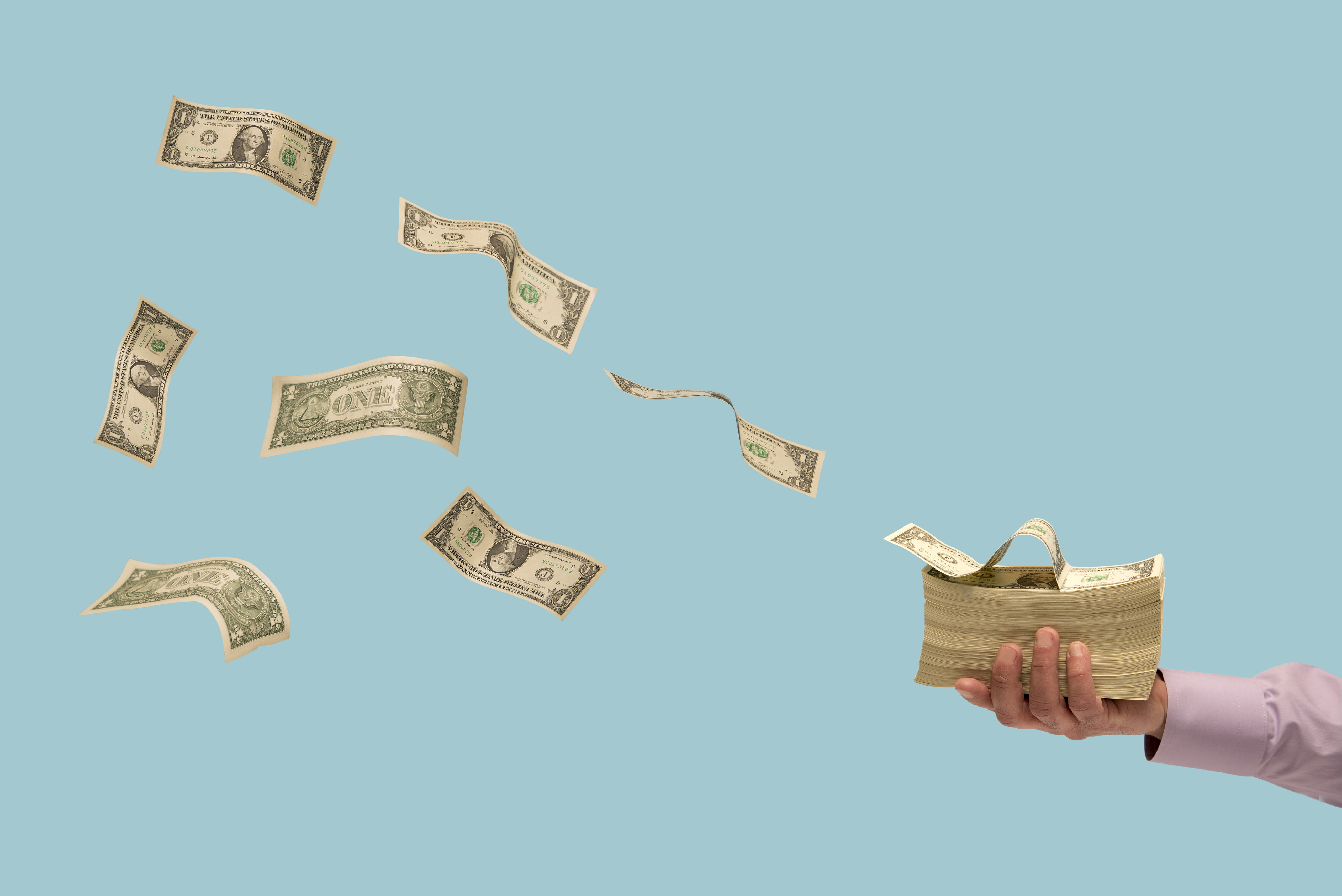 Money flying off stack of bills