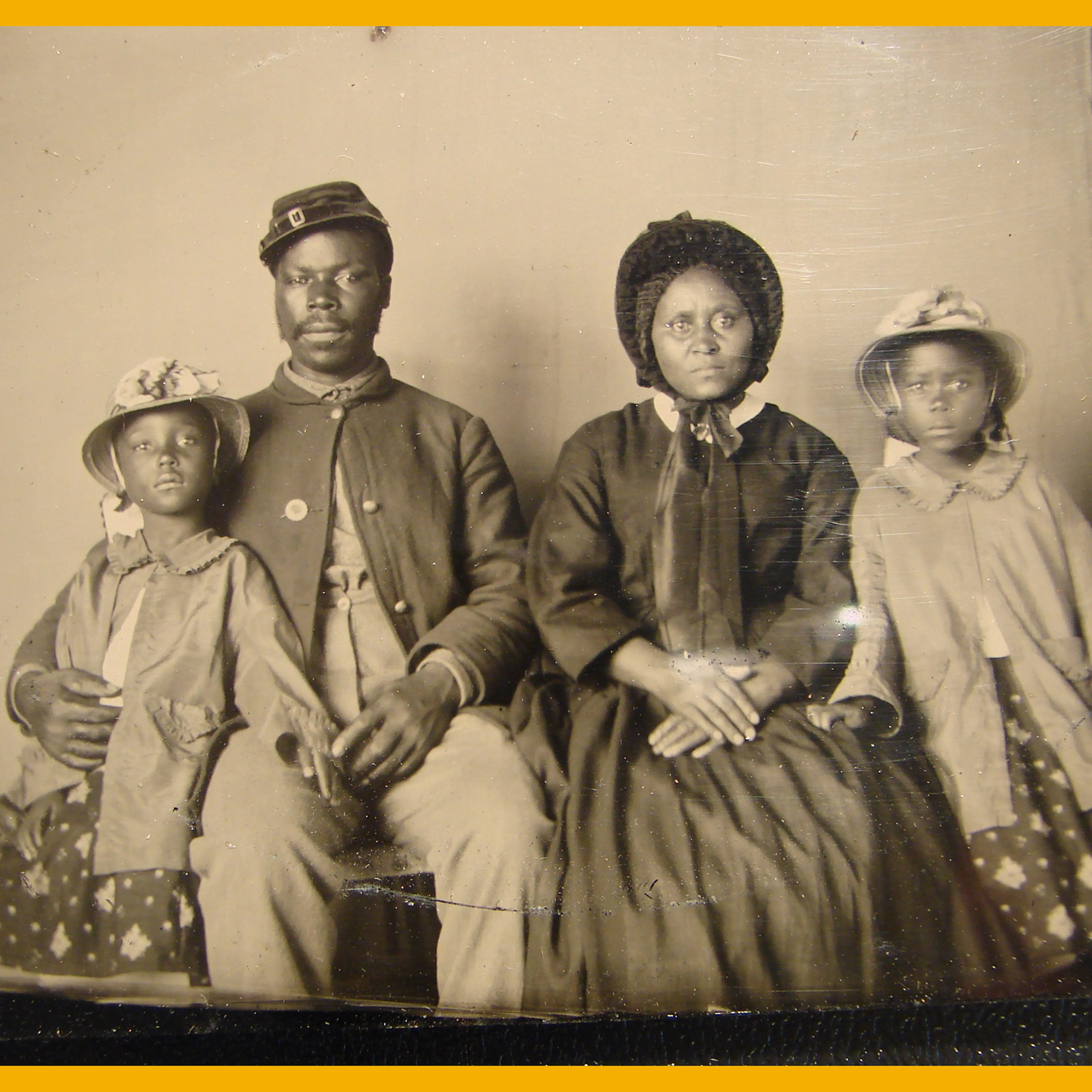 African American soldier in Union uniform with wife and two daughters, circa 1863 - 1865.