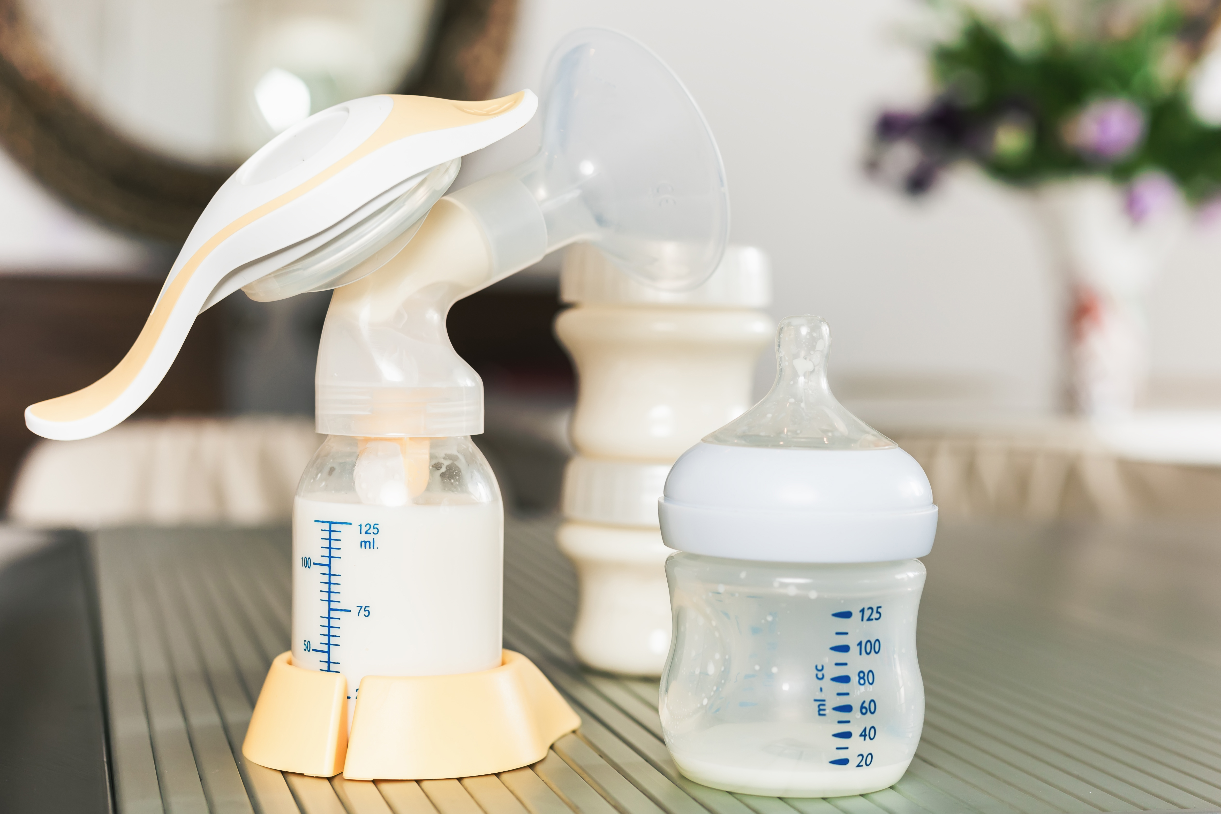 Baby bottle with milk and manual breast pump