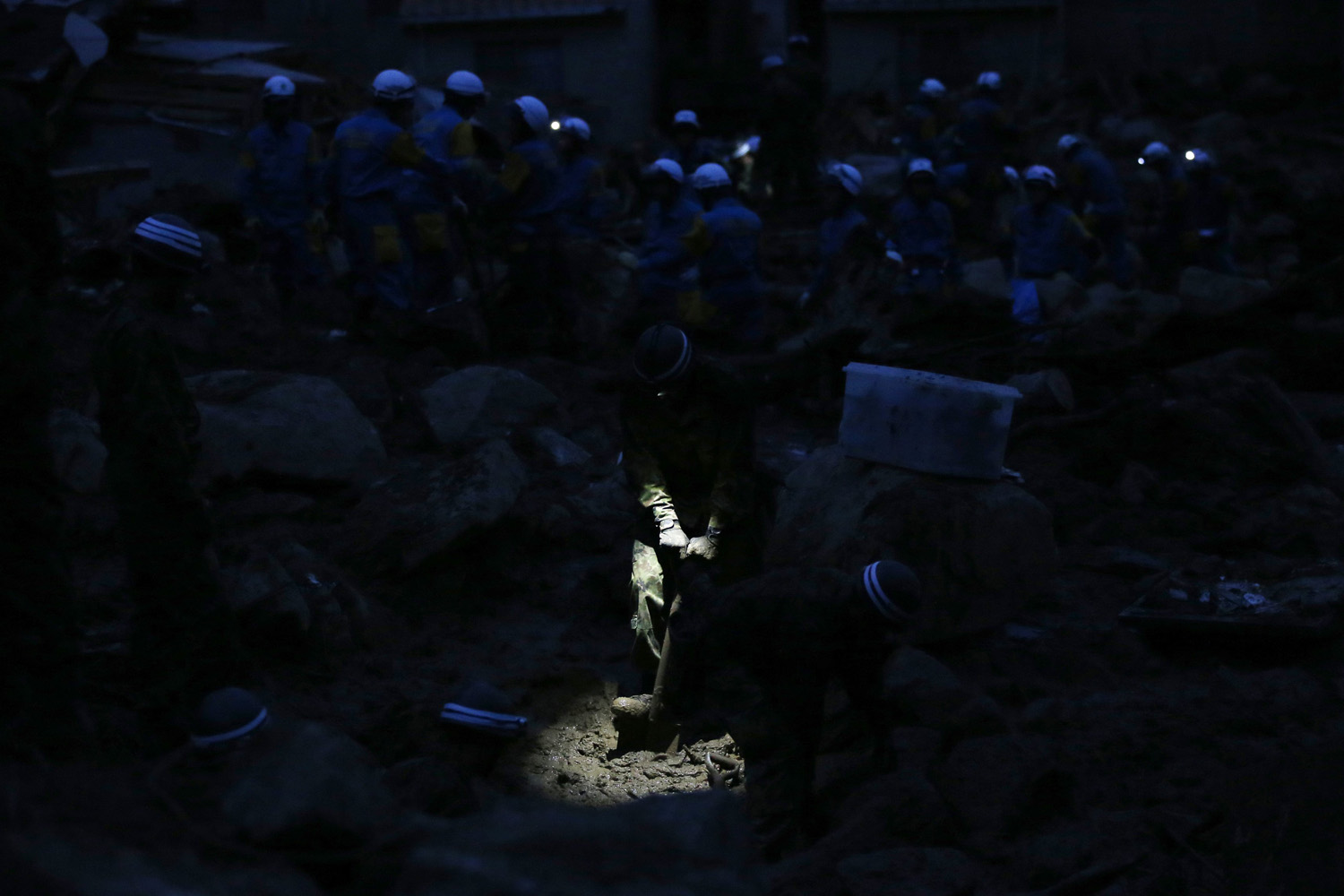JSDF soldier searches for survivors at dusk at a site where a landslide swept through a residential area at Asaminami ward in Hiroshima