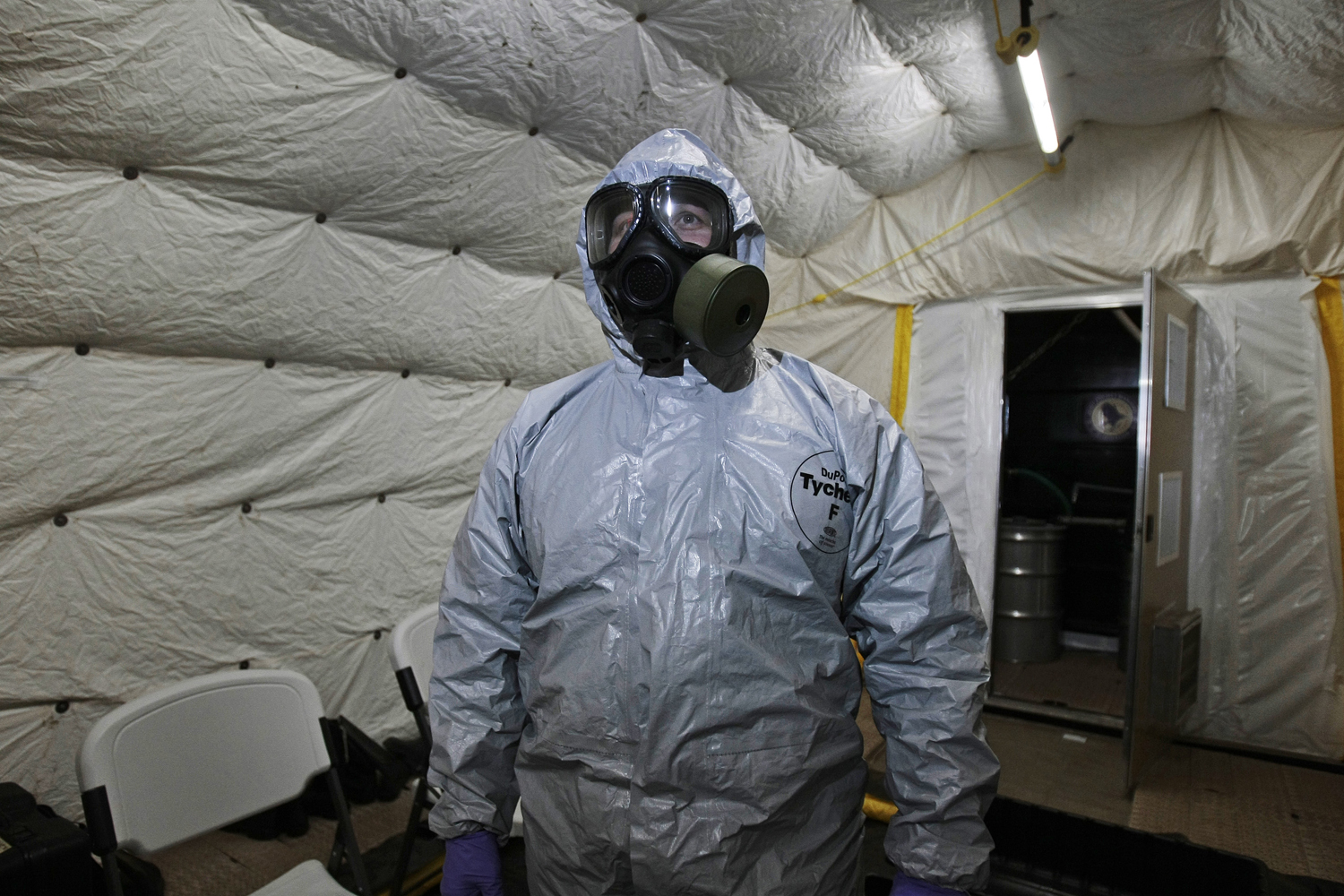 A marine officer of the Cape Ray, a ship equipped to neutralize Syrian chemicals, shows a chemical protection suit to reporters during a tour around the ship docked at the naval base of Rota used by the U.S, in Spain’s southwestern coast on April 10, 201