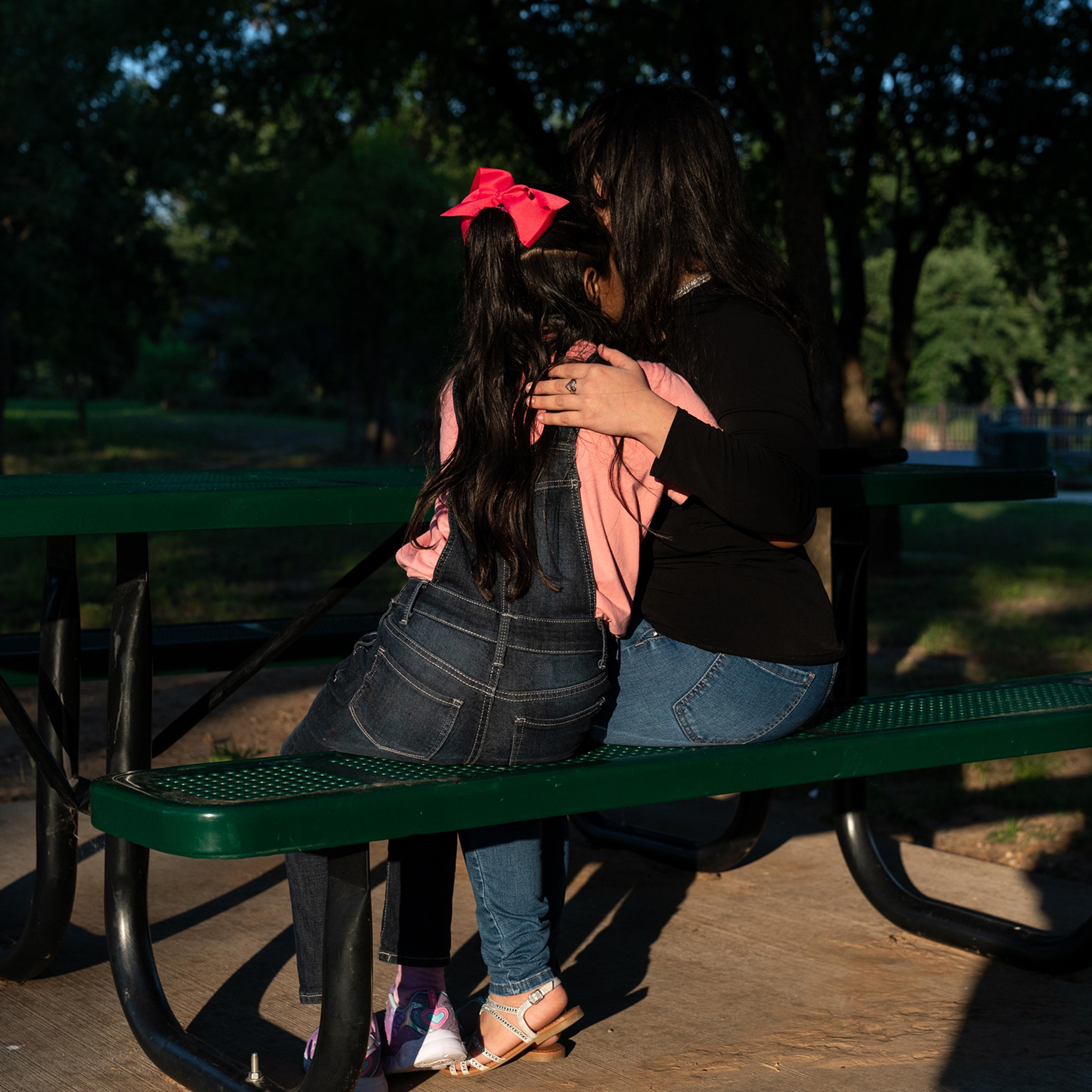 Estefani and her eight-year-old daughter, Ashly, embrace in a park near the home of relatives in June.