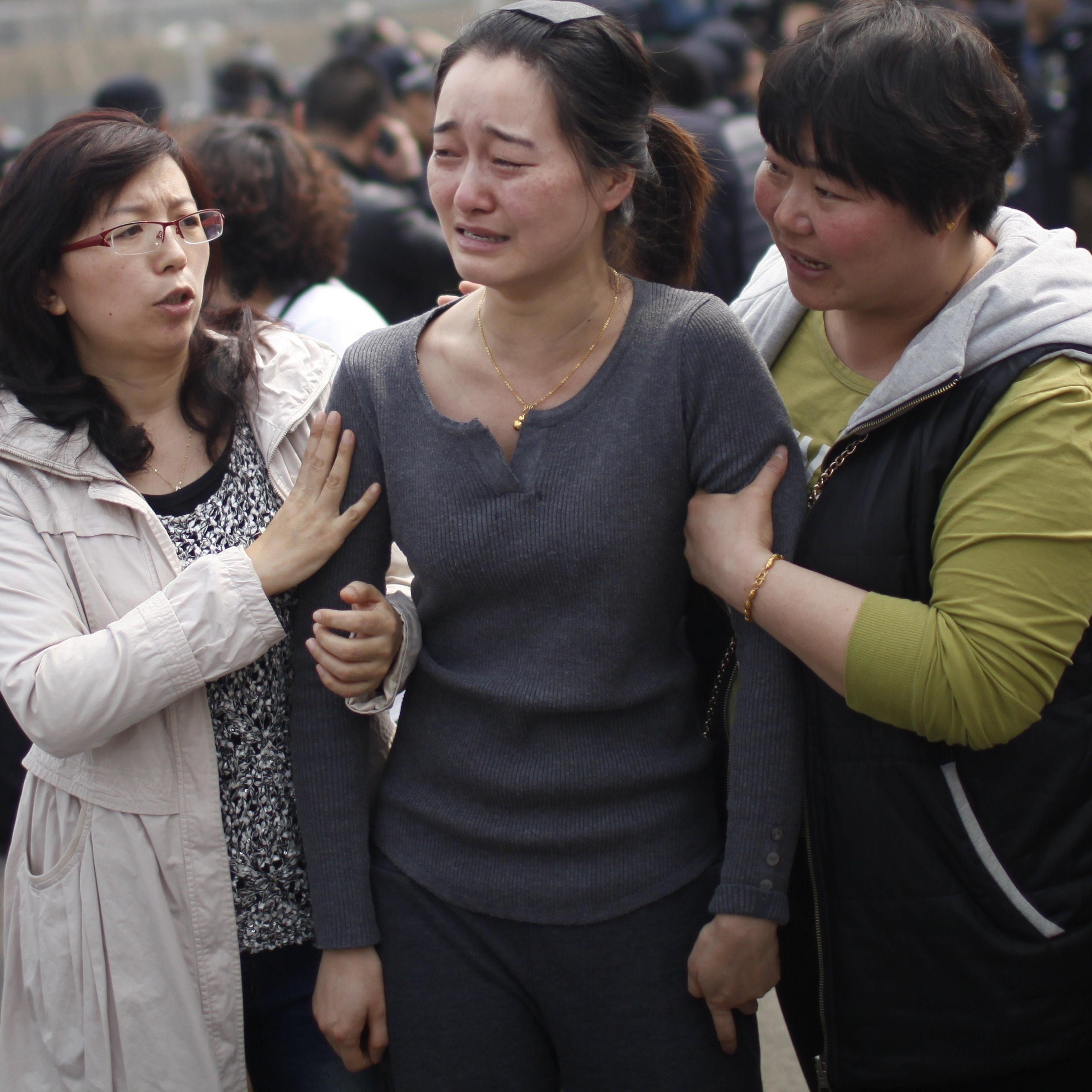 A relative of passengers on the missing Malaysia Airlines flight MH370 cries as she participates in a protest outside the Malaysian embassy in Beijing on March 25, 2014.