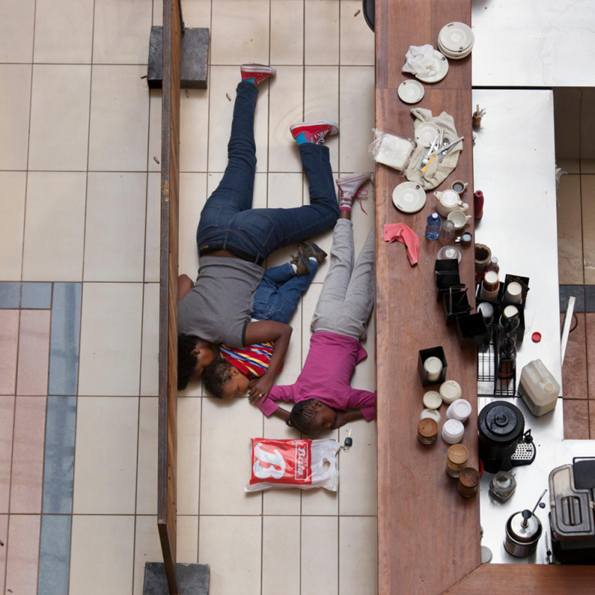A woman and children hide inside Westgate Mall in Nairobi, Kenya, Sept. 21, 2013.