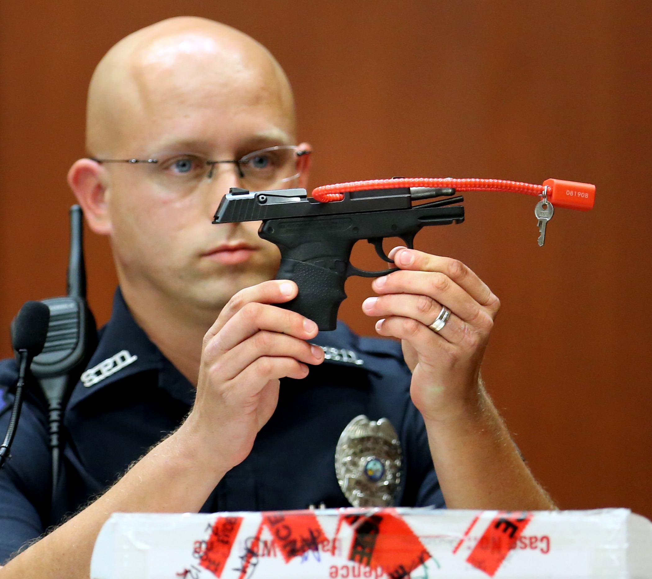 Sanford police officer Timothy Smith holds up the gun that was used to kill Trayvon Martin, while testifying on the 15th day of George Zimmerman's trial in Seminole Circuit Court in Sanford, Fla., June 28, 2013.