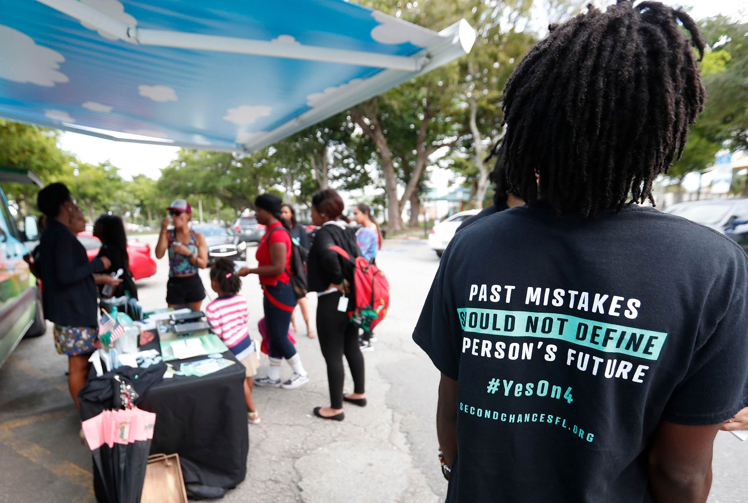 People gather around the Ben &amp; Jerry's "Yes on 4" truck as they learn about Amendment 4 and eat free ice cream at Charles Hadley Park in Miami on Oct. 22, 2018.