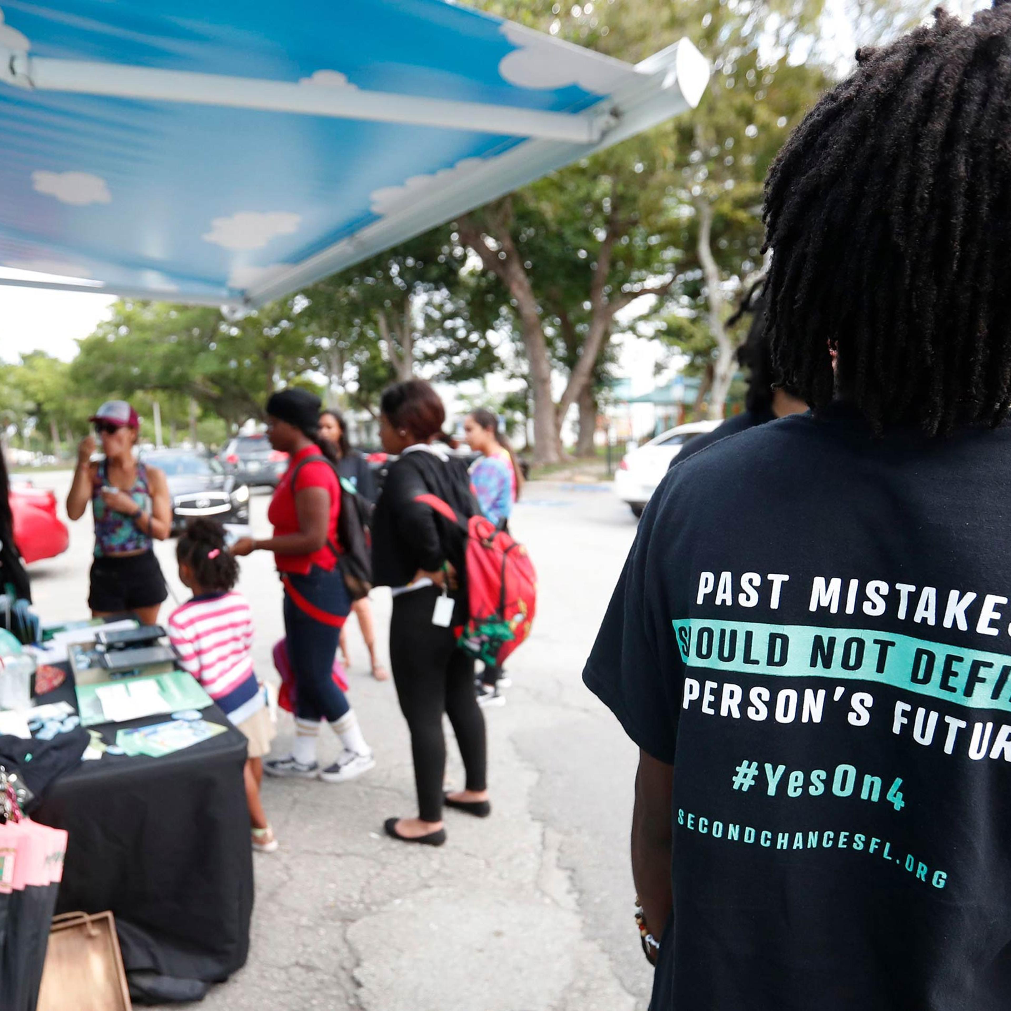 People gather around the Ben & Jerry's "Yes on 4" truck as they learn about Amendment 4 and eat free ice cream at Charles Hadley Park in Miami on Oct. 22, 2018.