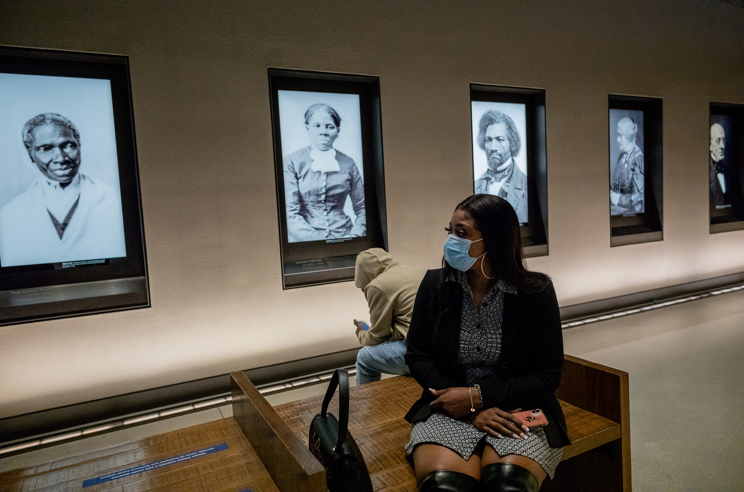 Bridgett Floyd sits among famous portraits at a tour of the National Museum of African American History and Culture on Sunday.