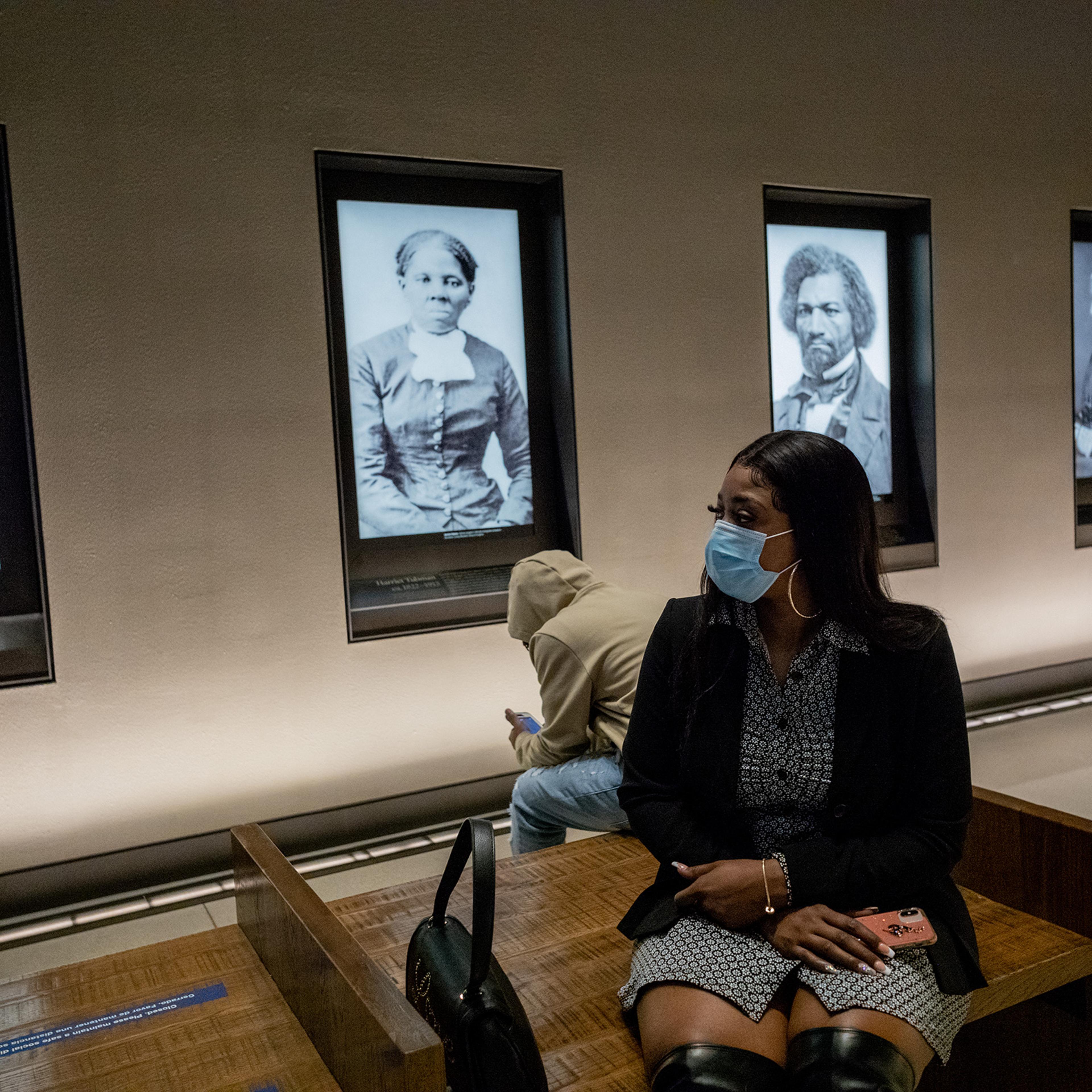 Bridgett Floyd sits among famous portraits at a tour of the National Museum of African American History and Culture on Sunday.