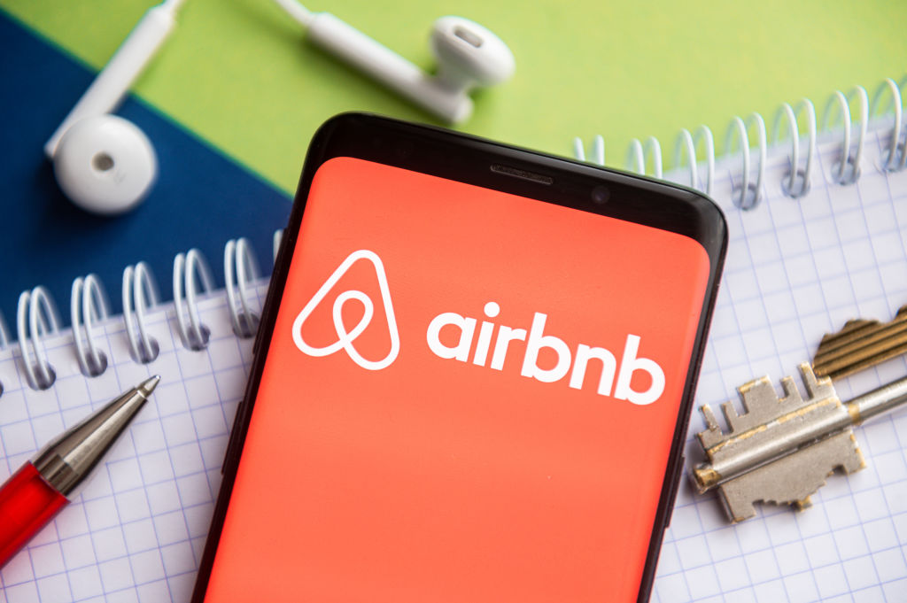 In this photo illustration, an Airbnb logo seen displayed on