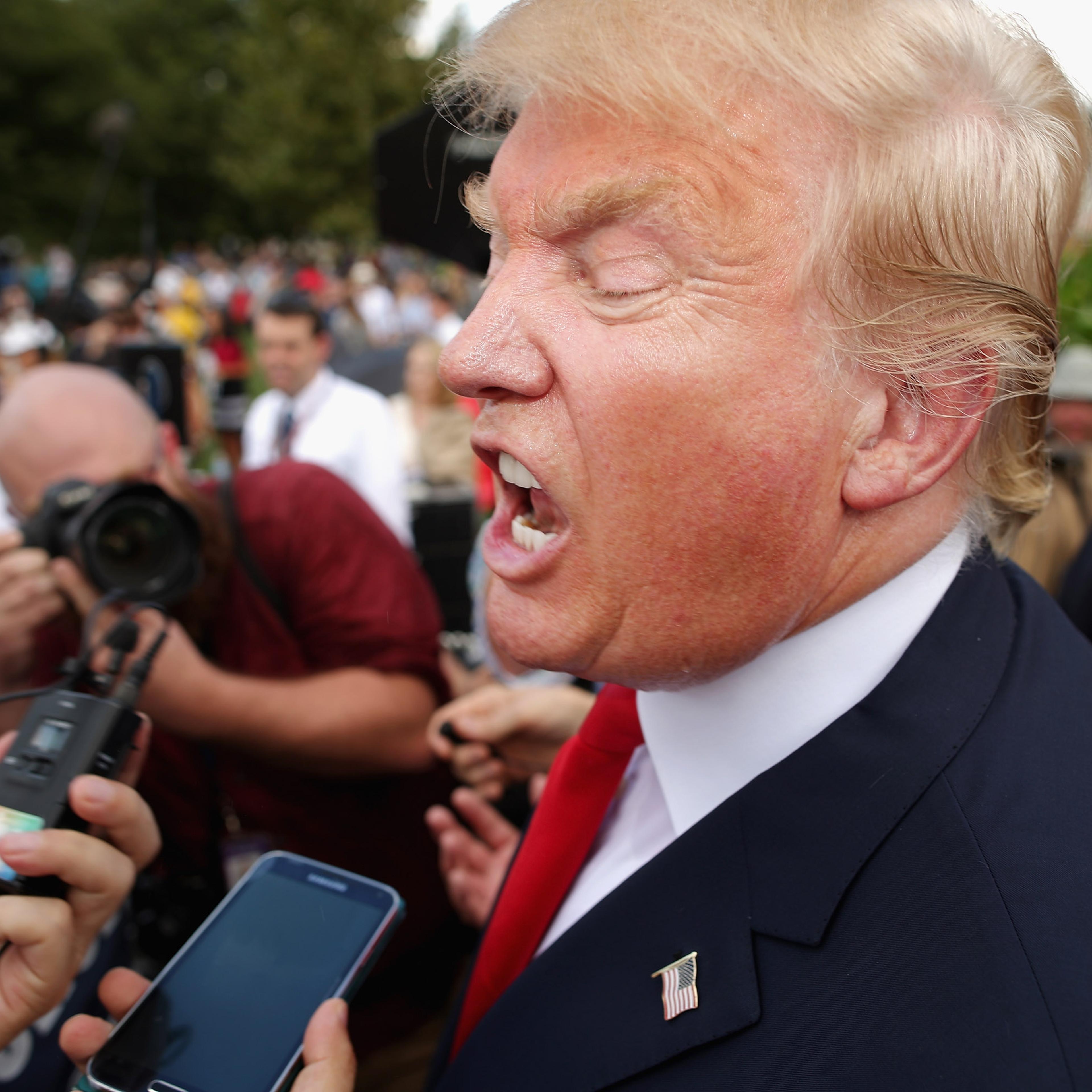 Republican presidential candidate Donald Trump (2nd L) talks with journalists during a rally against the Iran nuclear deal on the West Lawn of the U.S. Capitol September 9, 2015 in Washington, DC.