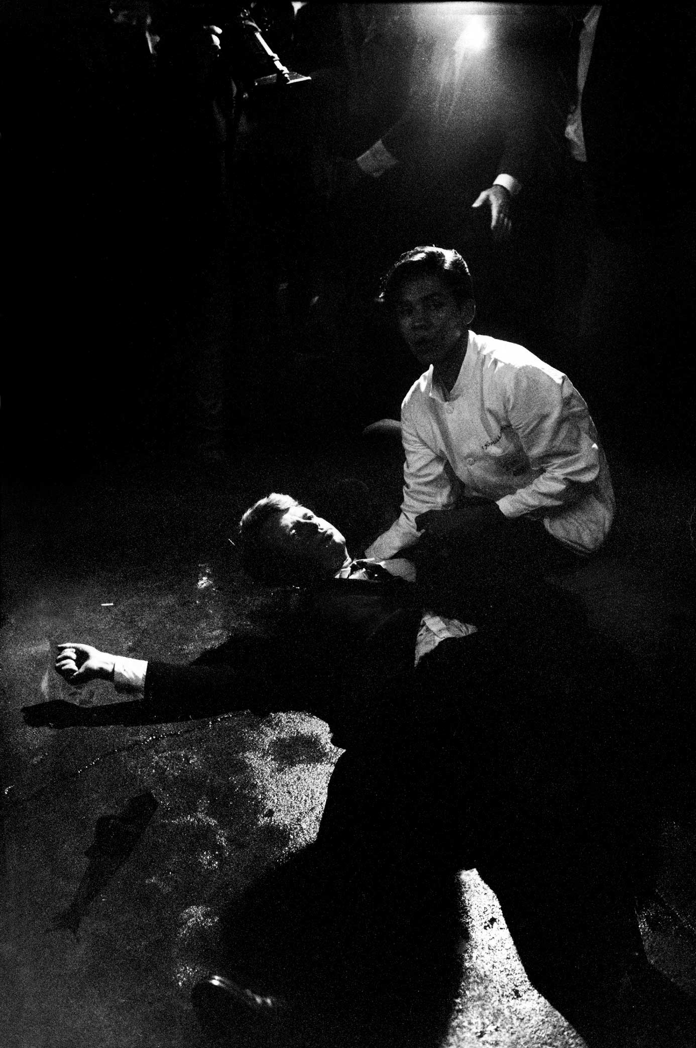 Senator Robert Kennedy lies in a pool of his own blood on the floor of the kitchen at Los Angeles' Ambassador Hotel, June 5, 1968, after being shot by Jordanian-born assassin Sirhan Sirhan. A dazed, frightened hotel busboy, Juan Romero, tries to comfort 