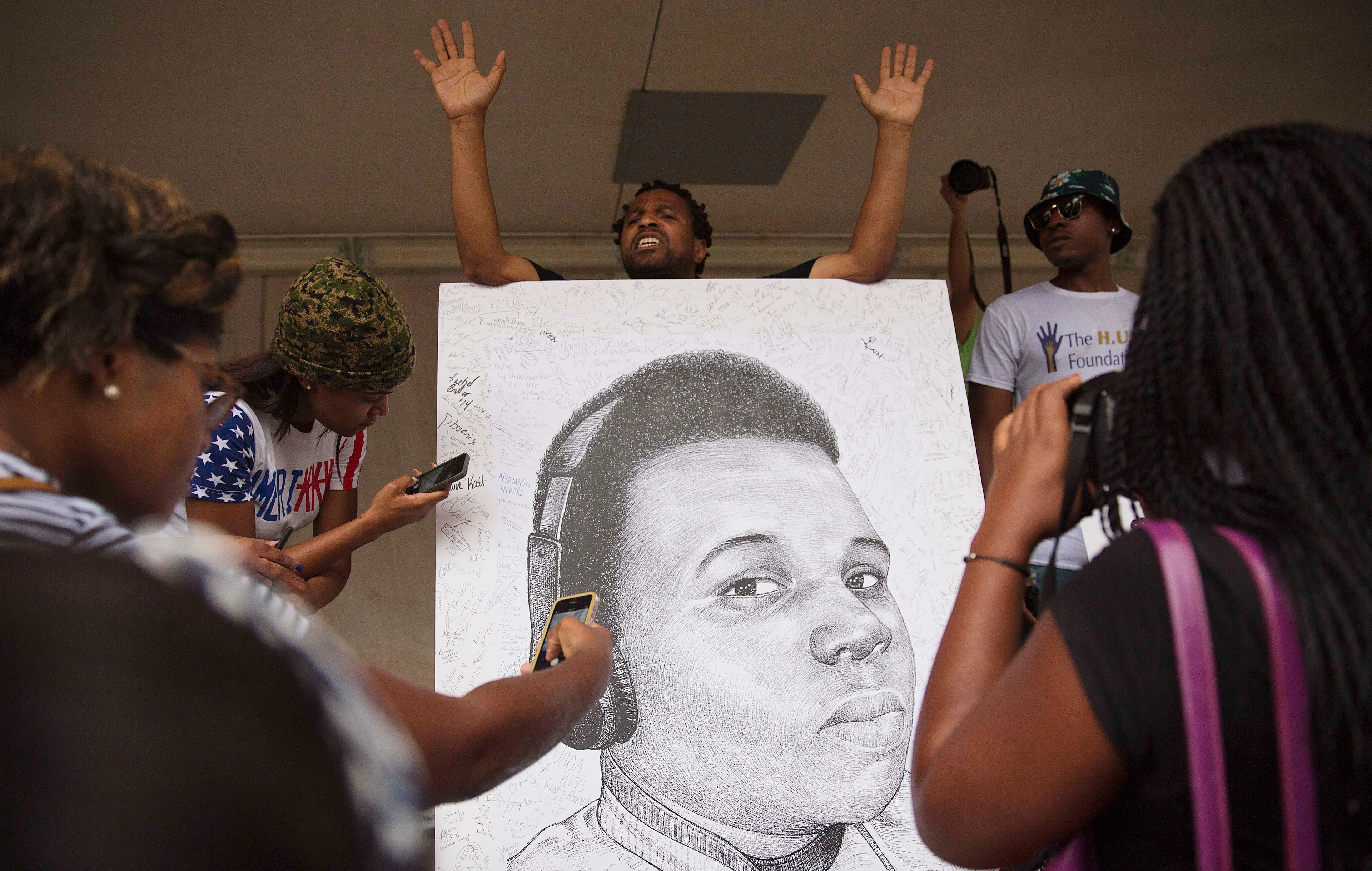 Demonstrators autograph a drawing of Michael Brown during a protest against the fatal police shooting, in Atlanta on Aug. 18, 2014.