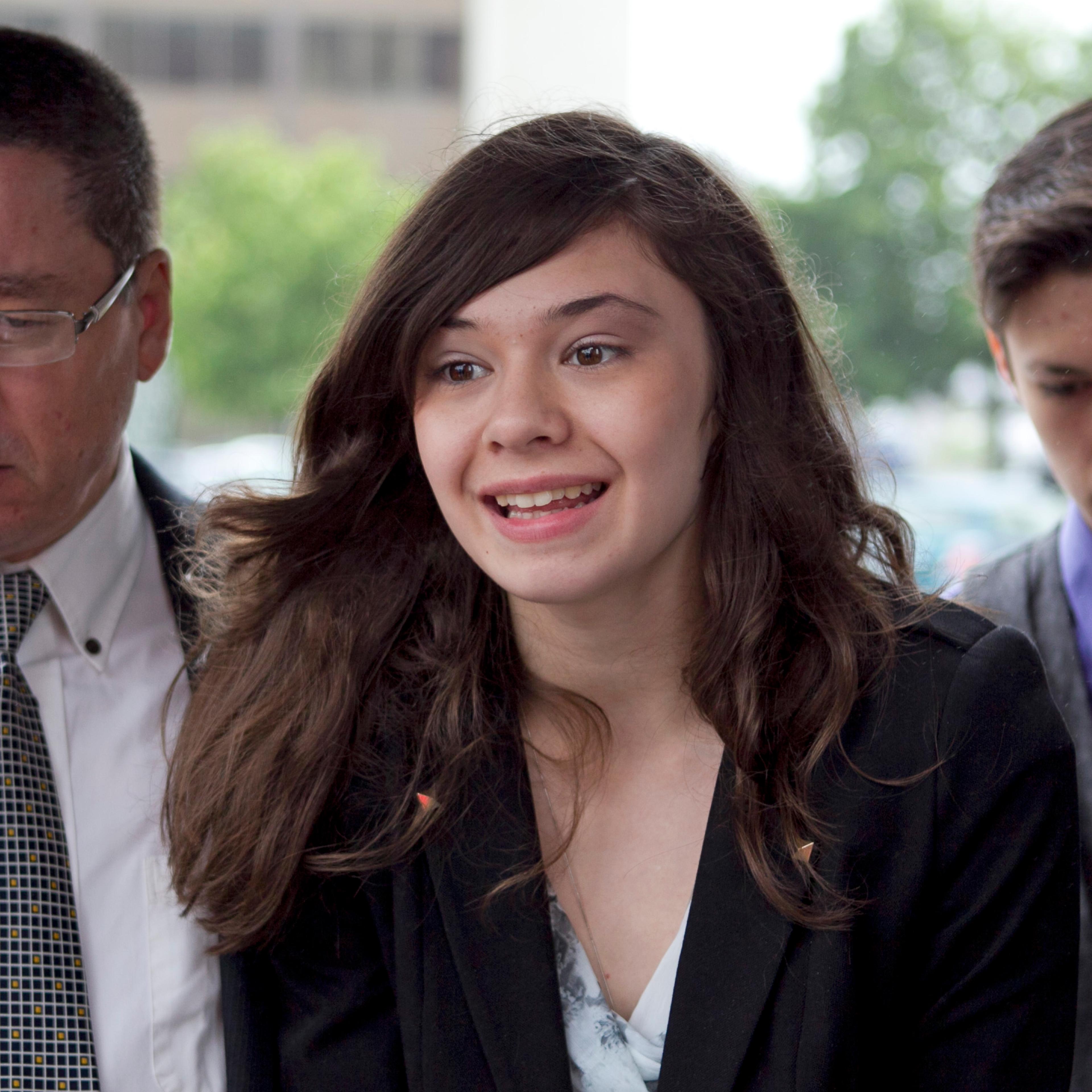 Transgender student Nicole Maines, center, speaks to reporters as her father Wayne Maines, left, and brother Jonas, look on outside the Penobscot Judicial Center in Bangor, Maine, on June 12, 2013.