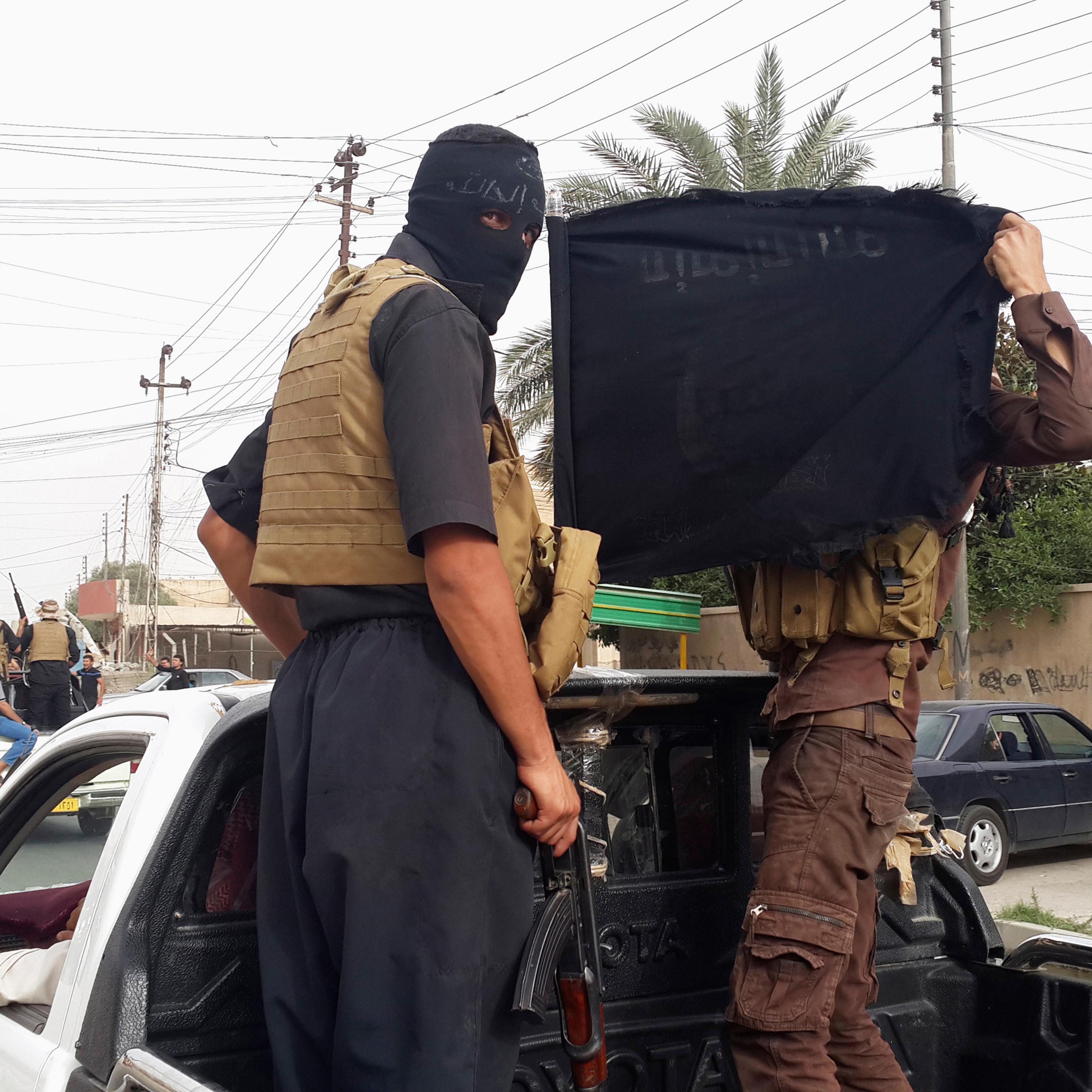 Fighters of the Islamic State of Iraq and the Levant (ISIL) celebrate on vehicles taken from Iraqi security forces, at a street in city of Mosul