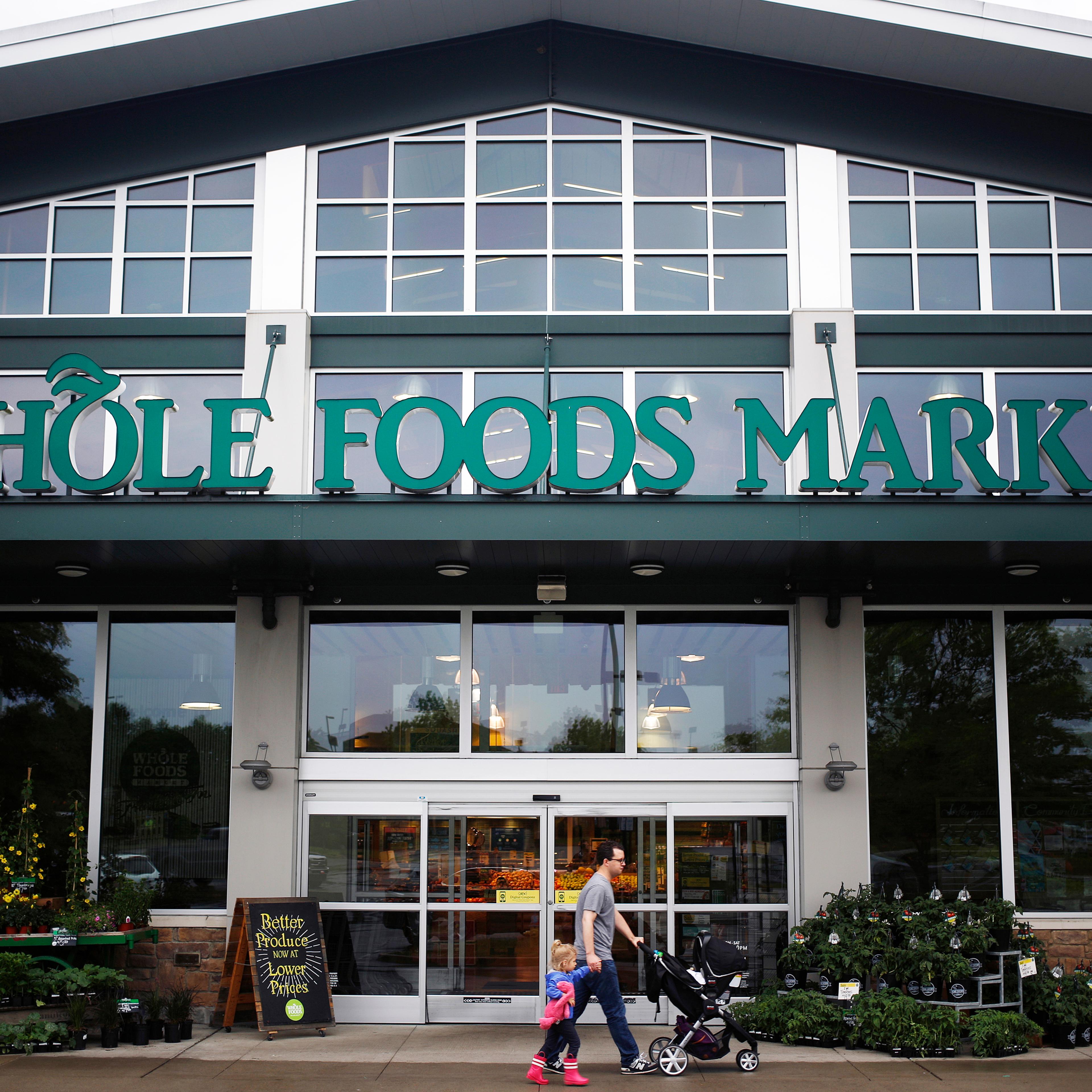 A shopper walks in front of a Whole Foods store in Franklin, Tenn. on April 30, 2016.