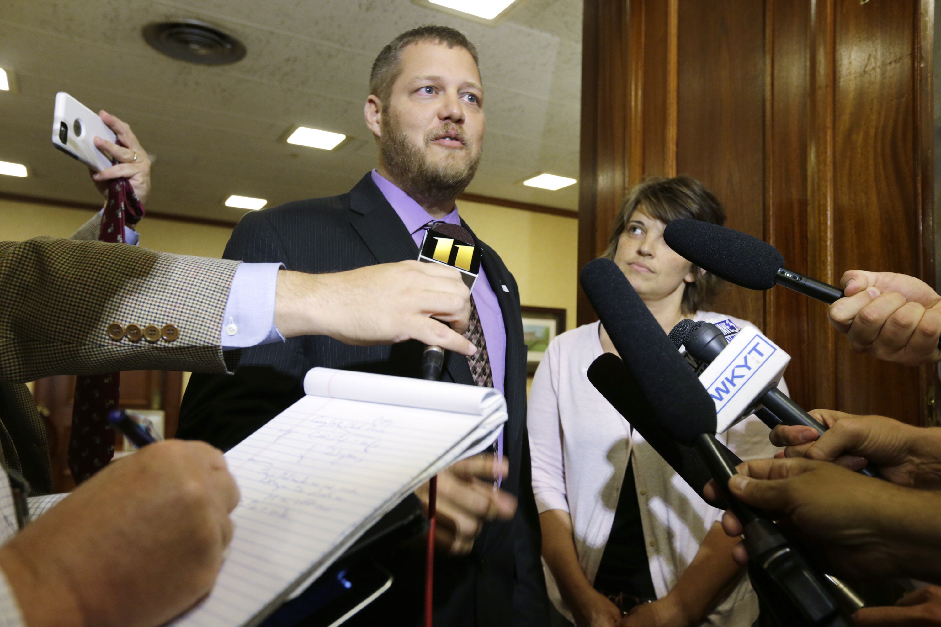 County Clerk Casey Davis (C), with wife Christy Davis (R), speak to the media before a meeting with Gov. Steve Beshear in Frankfort, Ky., on July 9, 2015.