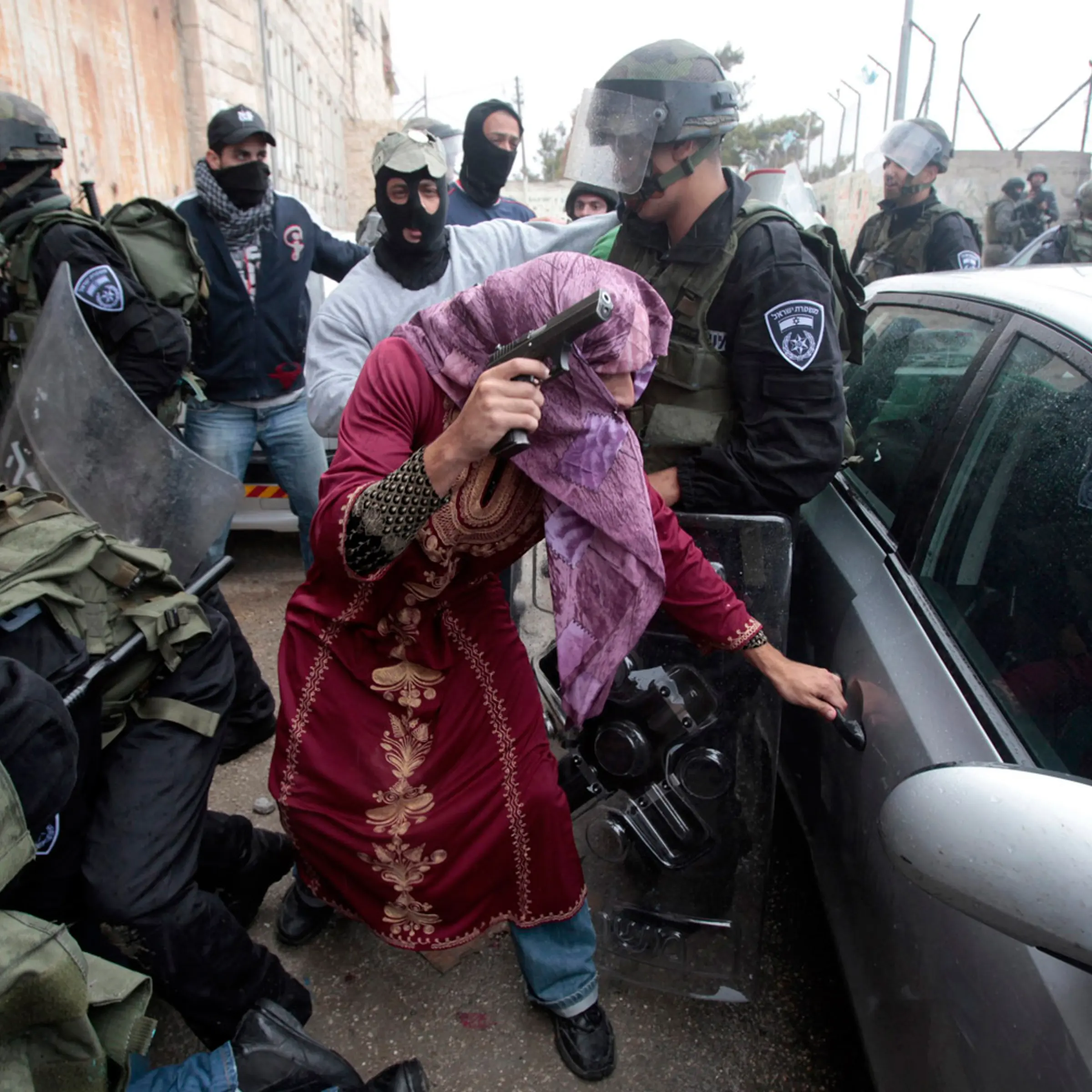 An undercover Israeli policeman dressed as a Palestinian woman opens a car door in the Shuafat refugee camp.