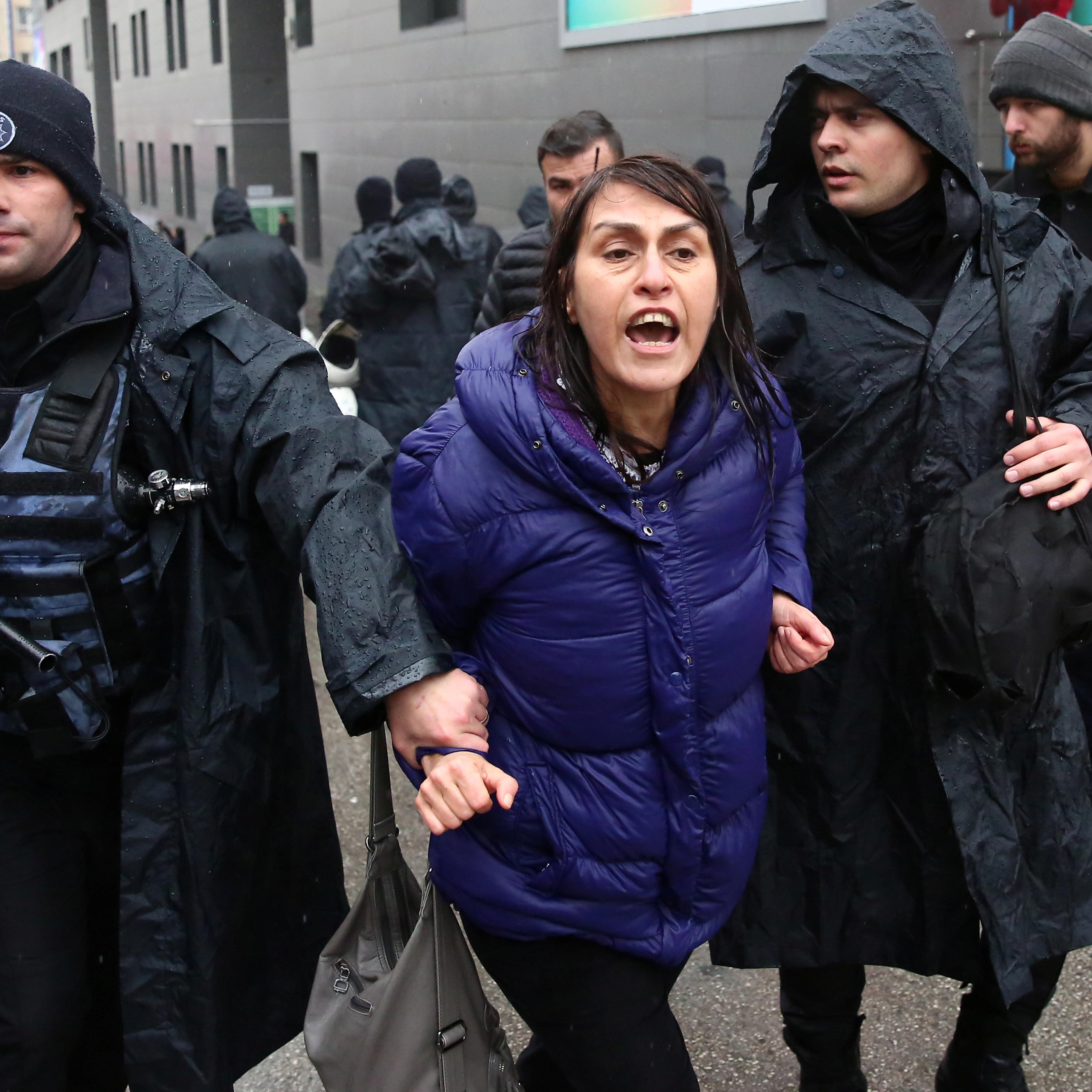 A woman is detained by riot police during a Women's Day rally in Ankara