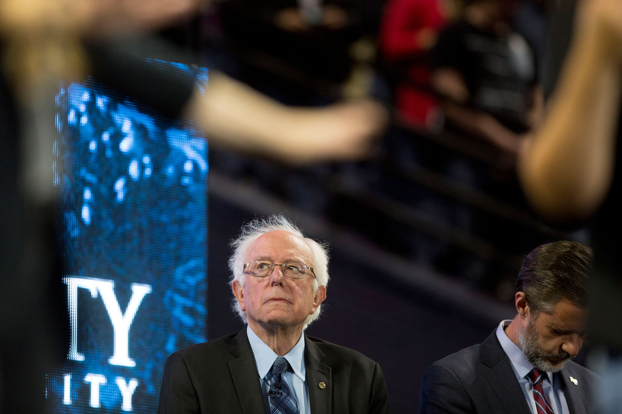 Senator Bernie Sanders, an independent from Vermont and 2016 Democratic presidential candidate, left, and Jerry Falwell Jr., president of Liberty University, listen to a prayer during a Liberty University Convocation in Lynchburg, Virginia, U.S., on Mond