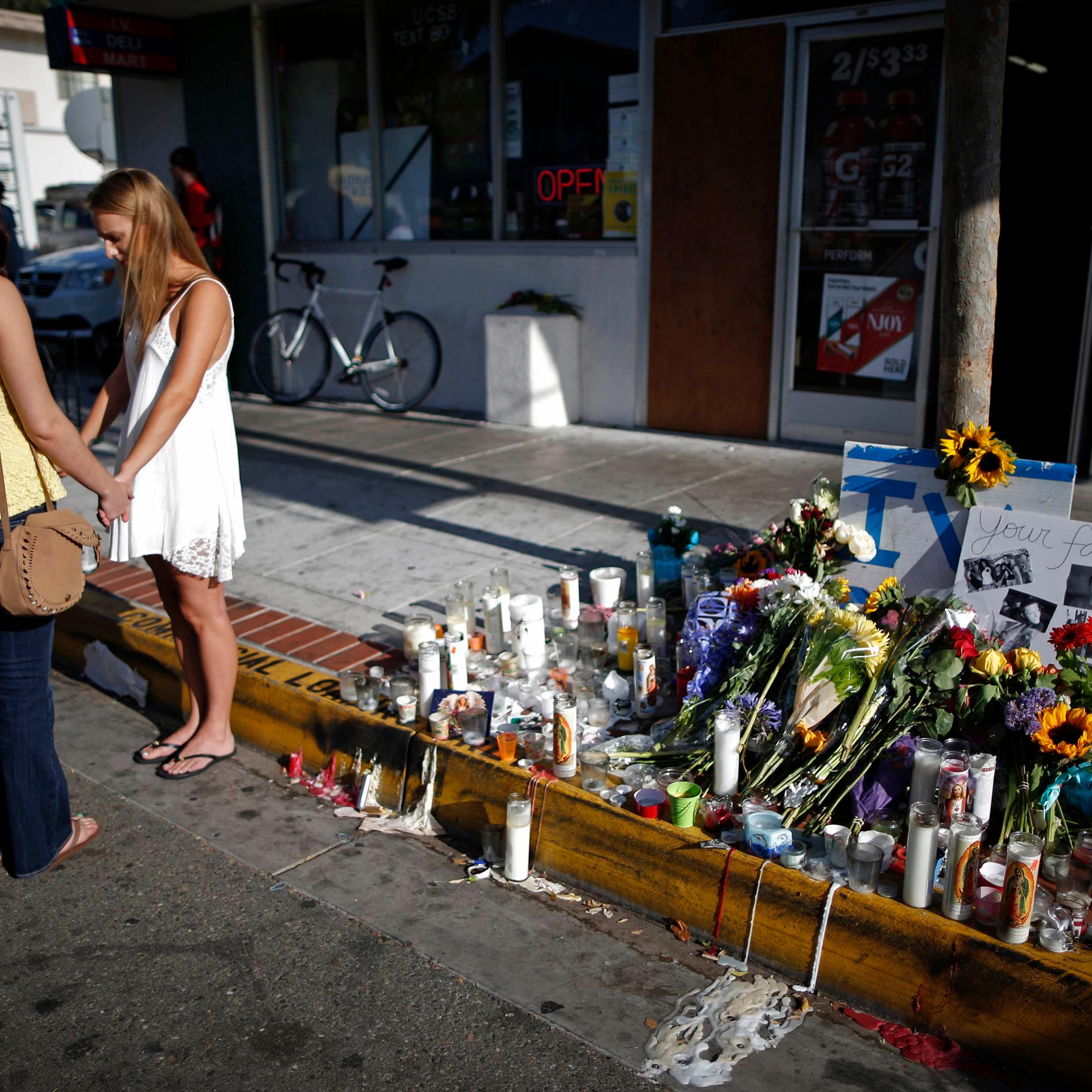 Women pray in front of a makeshift memorial for UCSB student Christopher Michael-Martinez in Isla Vista