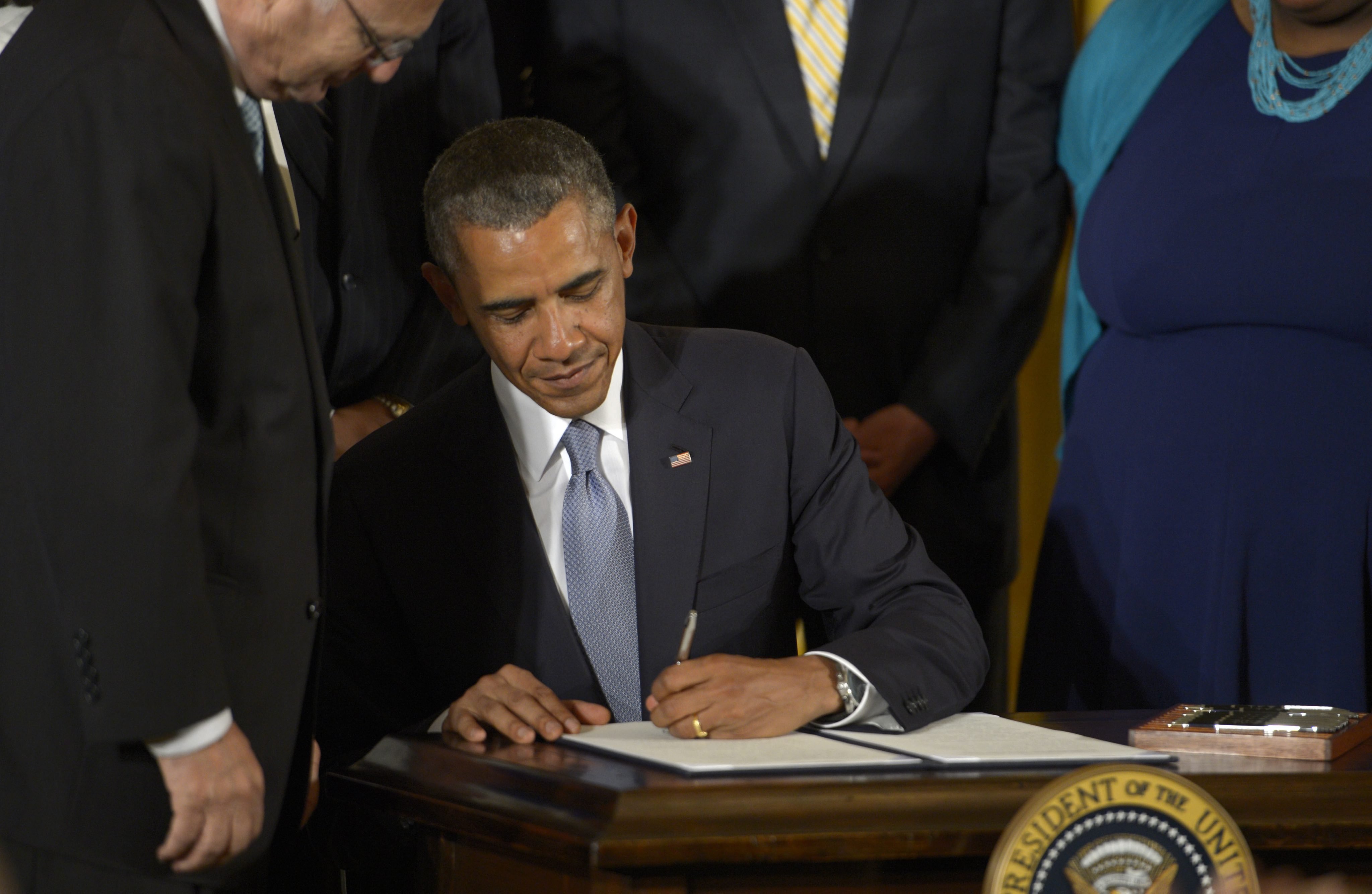 US President Barak Obama signs an Executive Order to protect LGBT employees from workplace discrimination during a ceremony in the the East Room of the White House in Washington on July 21, 2014.