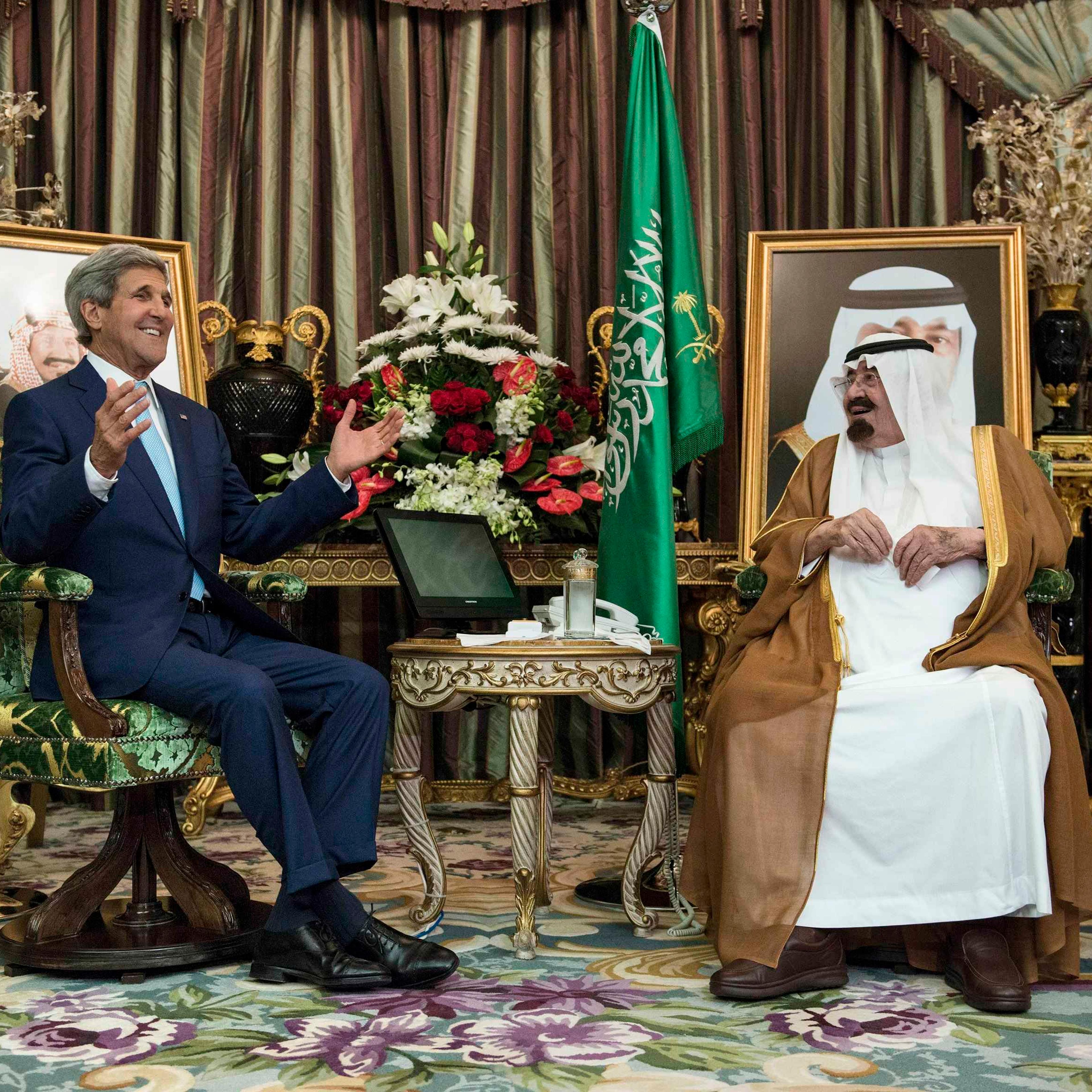 Saudi King Abdullah listens to U.S. Secretary of State Kerry before a meeting at the Royal Palace in Jeddah