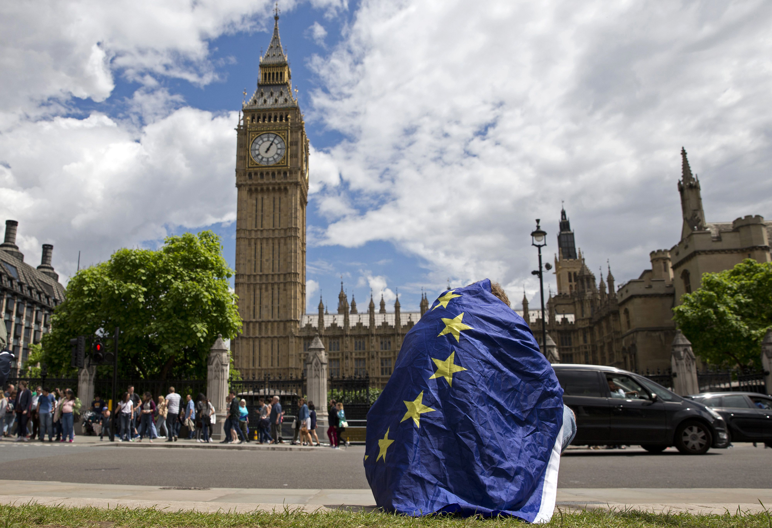 TOPSHOT - A demonstrator draped in an EU flag sits on floor during a protest against the outcome of the UK's June 23 referendum on the European Union (EU), in central London on June 25, 2016. The result of Britain's June 23 referendum vote to leave the E