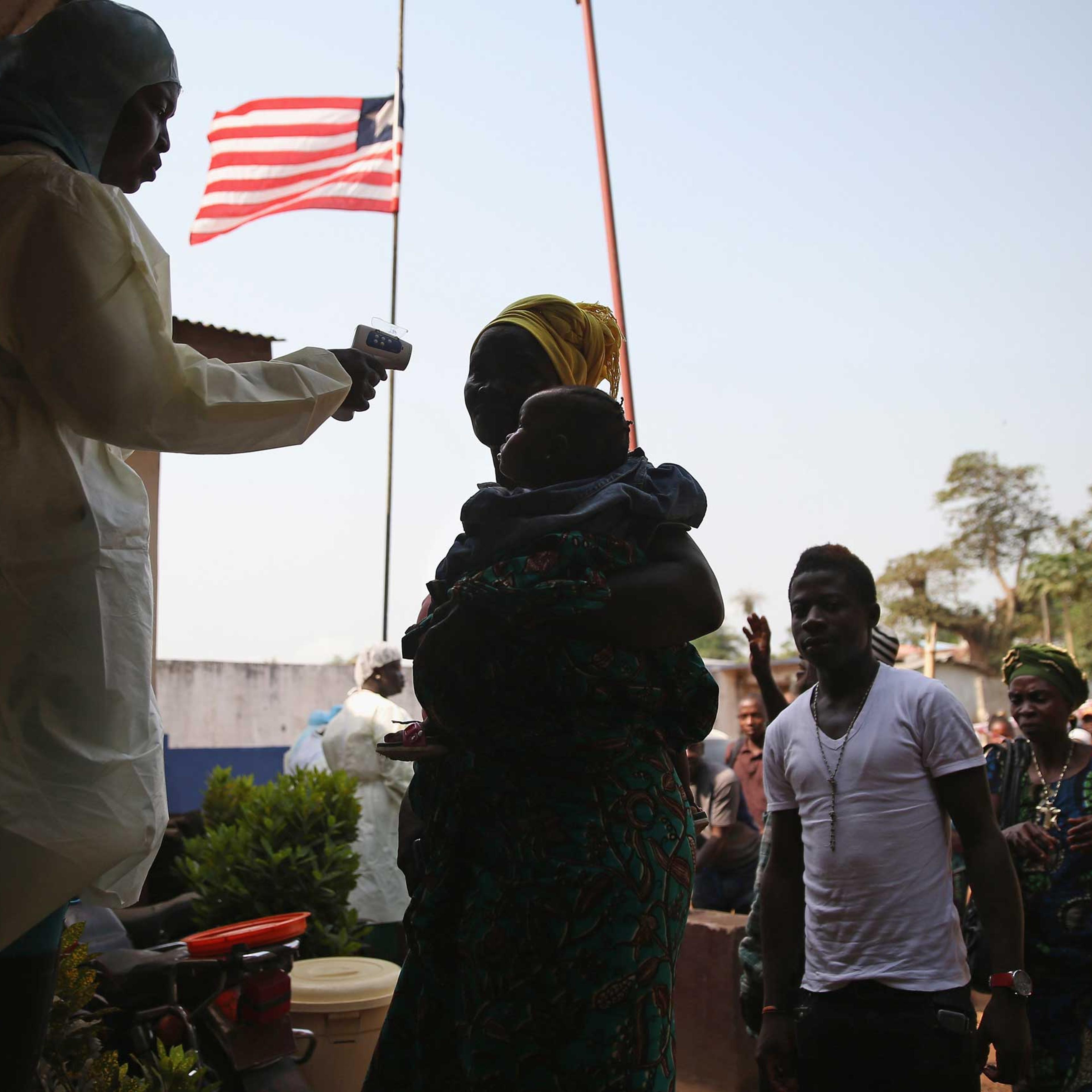 A health worker takes the temperature of a travelers at a highway checkpoint in Liberia on on Jan. 29, 2015.