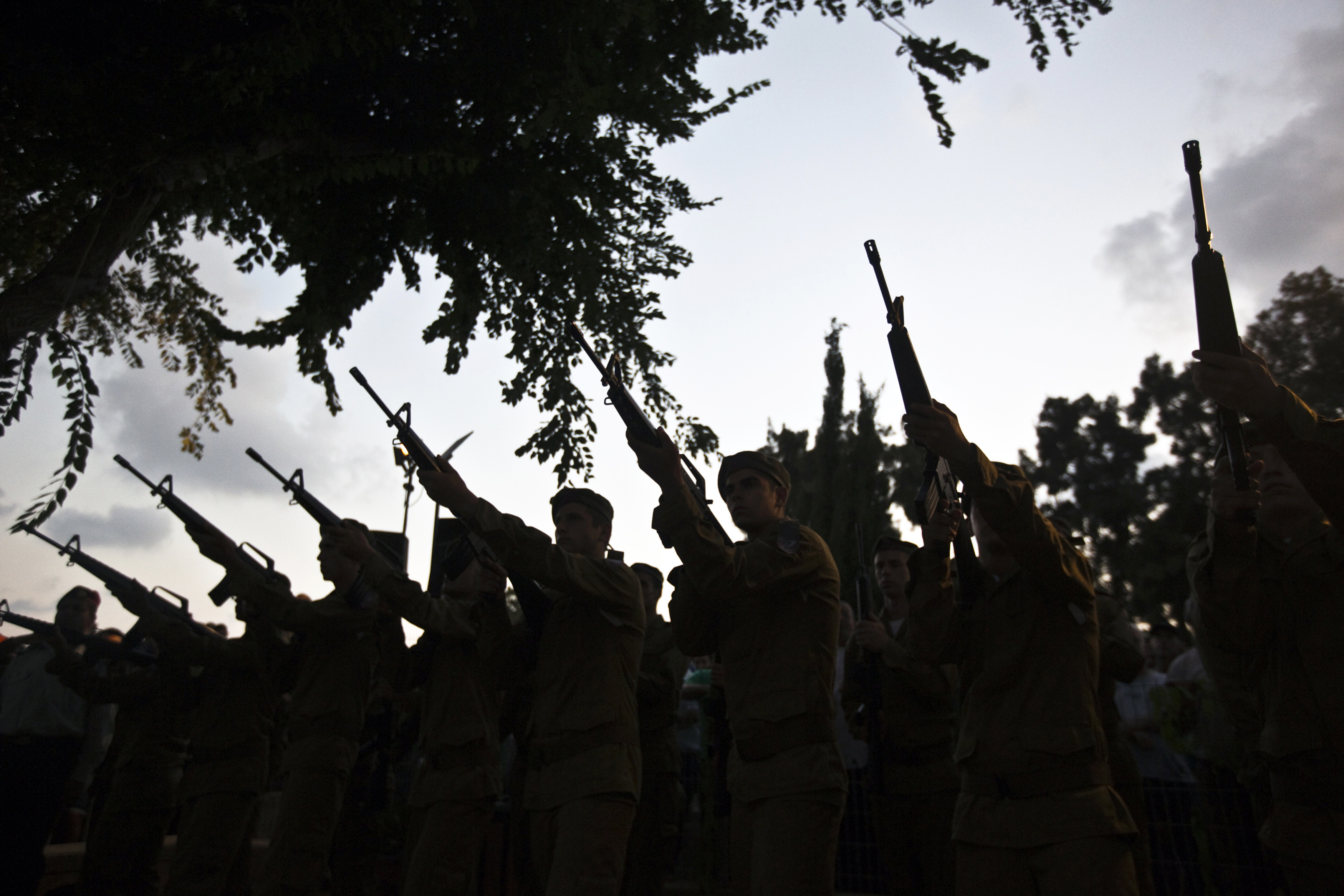 Israeli soldiers fire their weapons during the funeral of their comrade Bnaya Rubel in Holon
