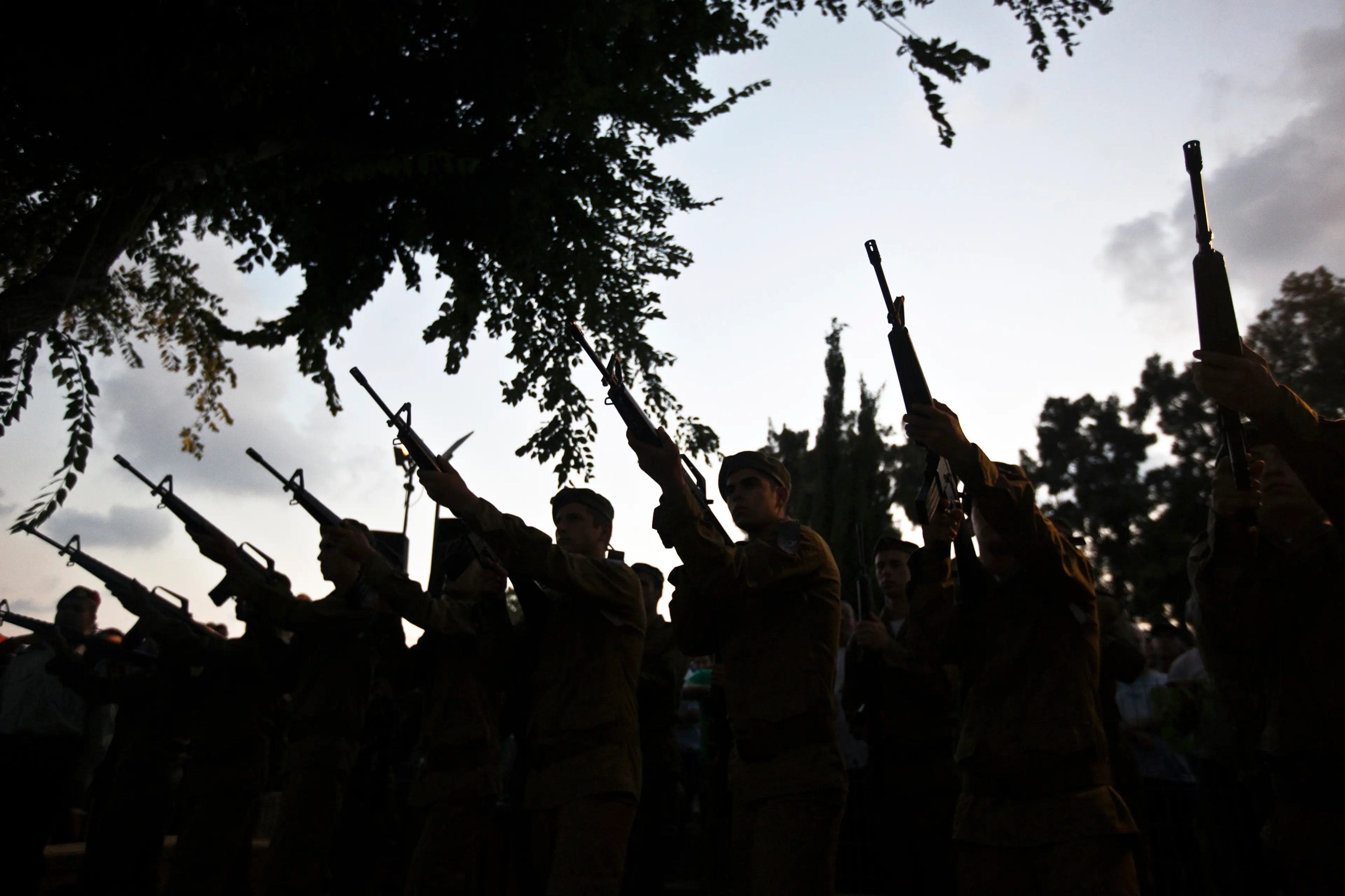 Israeli soldiers fire their weapons during the funeral of their comrade Bnaya Rubel in Holon