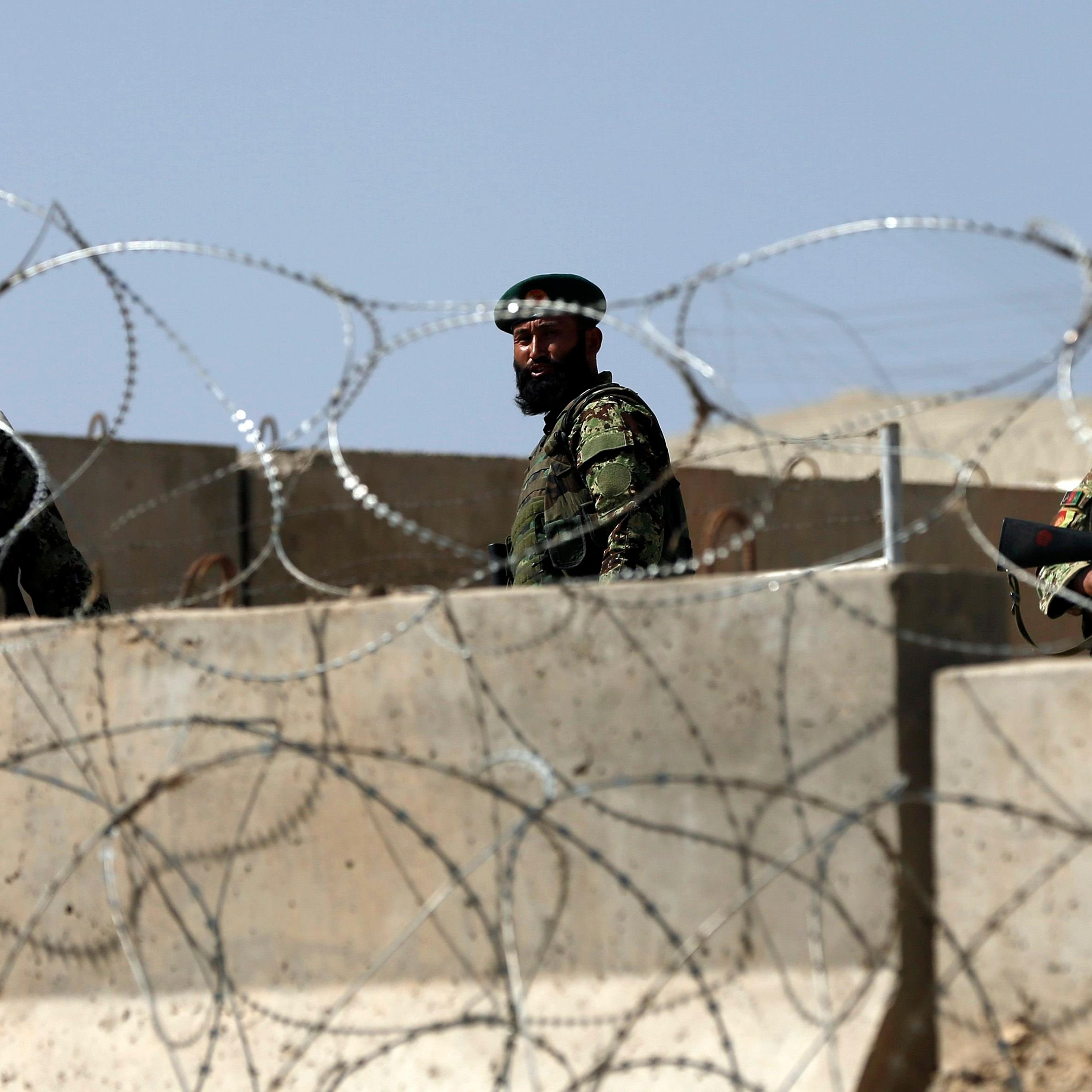 Afghan National Army soldiers keep watch at the gate of a British-run military training academy Camp Qargha, in Kabul on August 5, 2014.