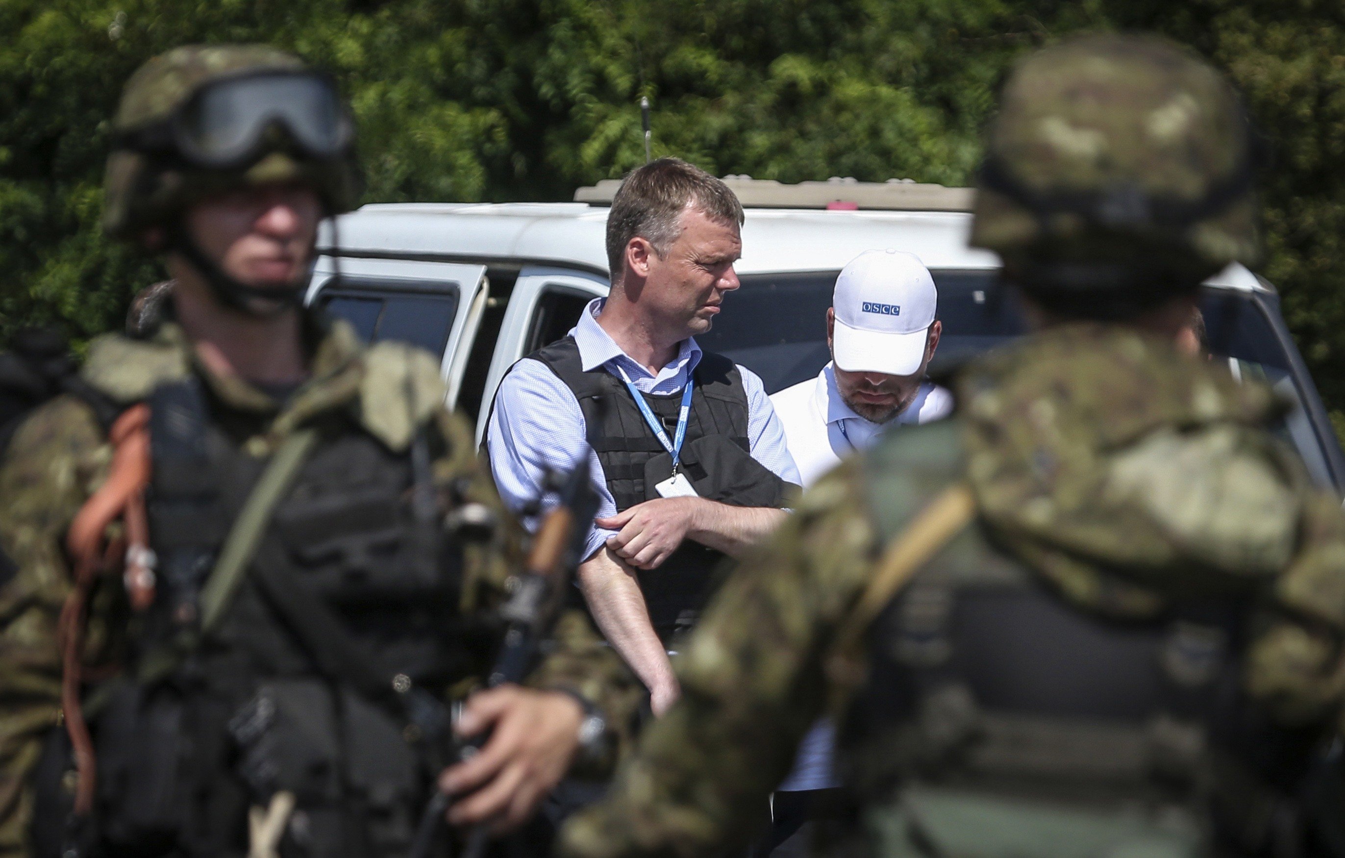 Alexander Hug deputy head for the Organisation for Security and Cooperation in Europe's (OSCE) monitoring mission in Ukraine, looks on next to armed pro-Russian separatists on the way to the Malaysia Airlines flight MH17 crash site, near Donetsk on July 