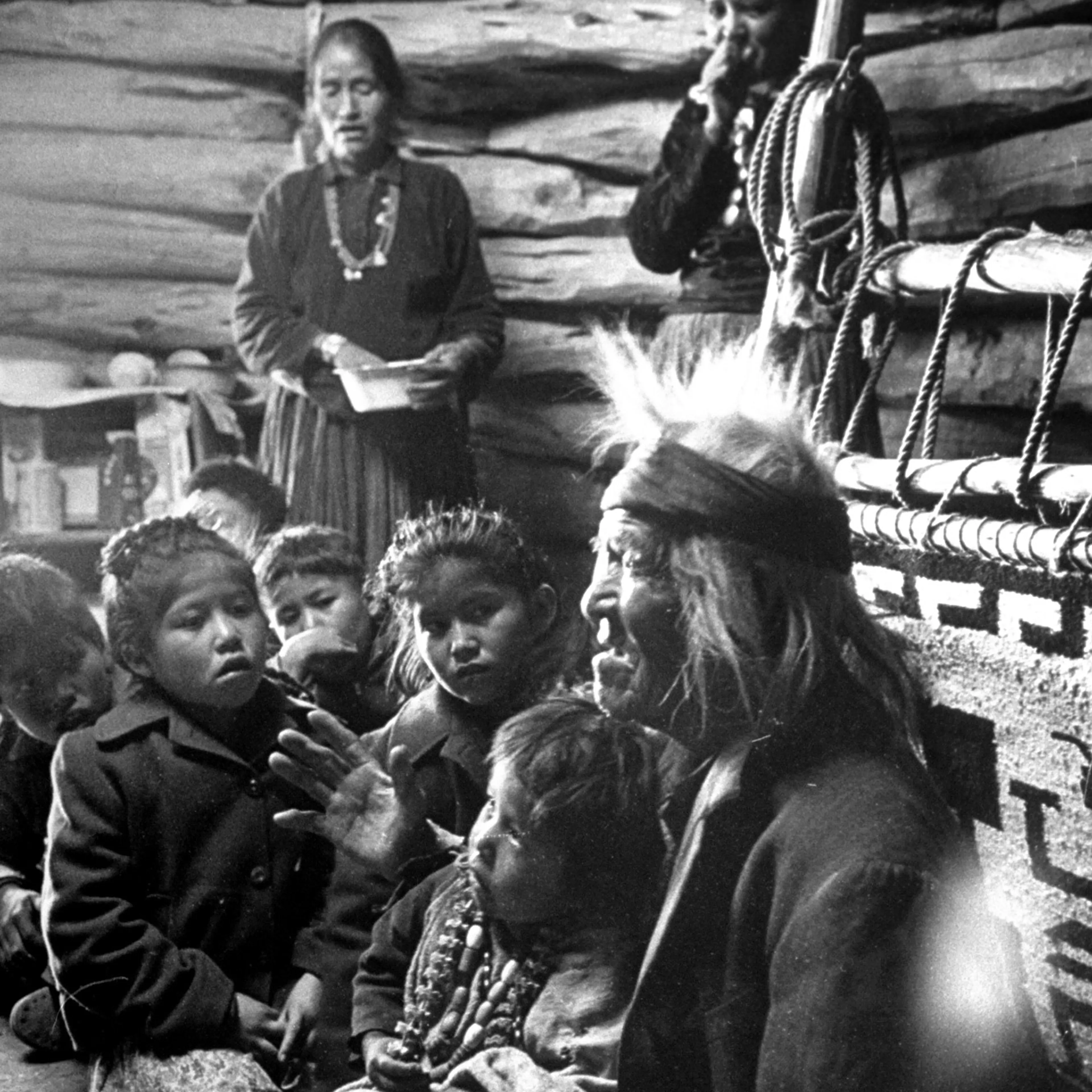 Seated close to the evening fire, old man Gray Mountain, 91, tells his small grandchildren legends about the early days of the Navajo people.