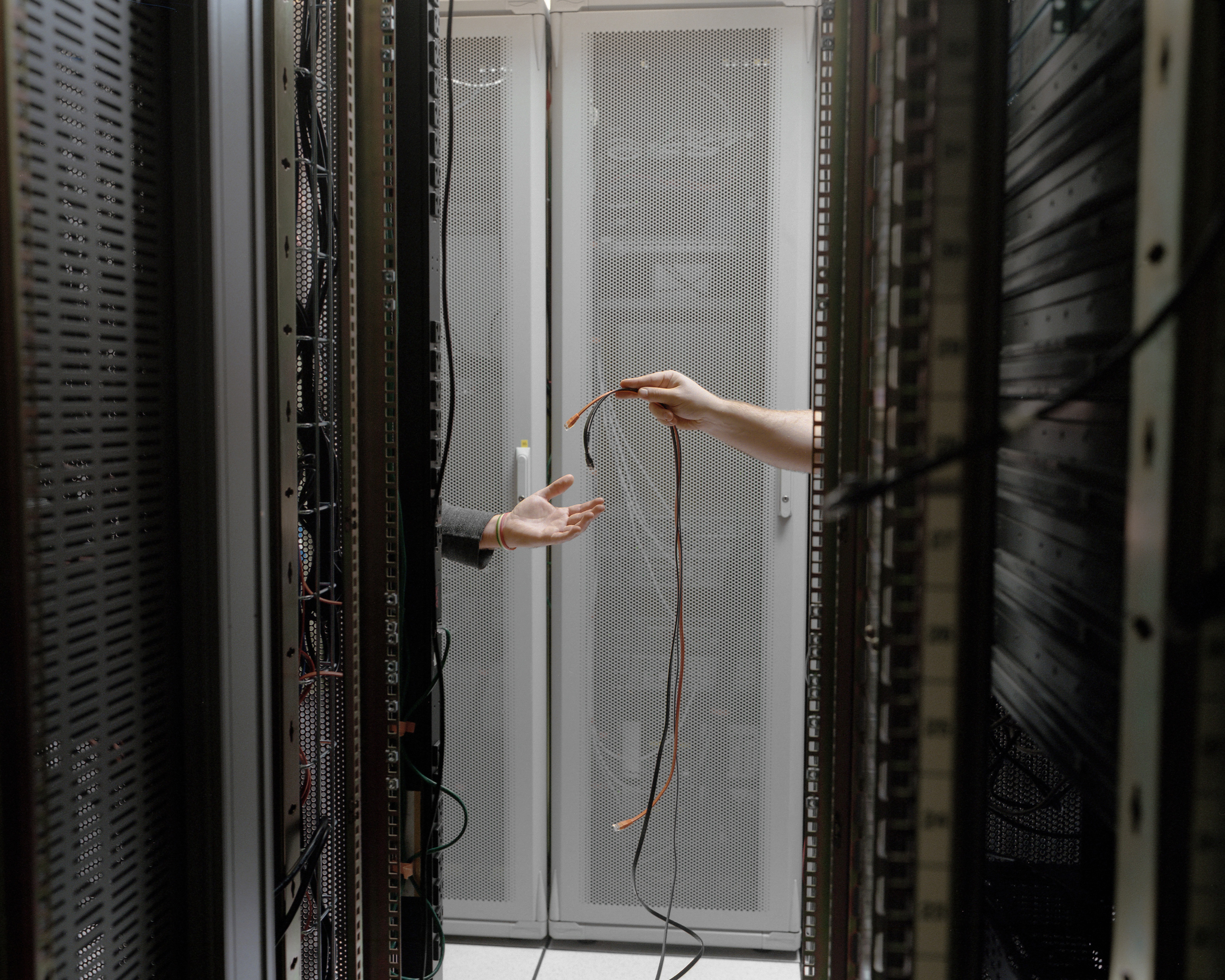 Workers replace cables at a telecommunications hub in New York where companies exchange Internet traffic to boost efficiency.