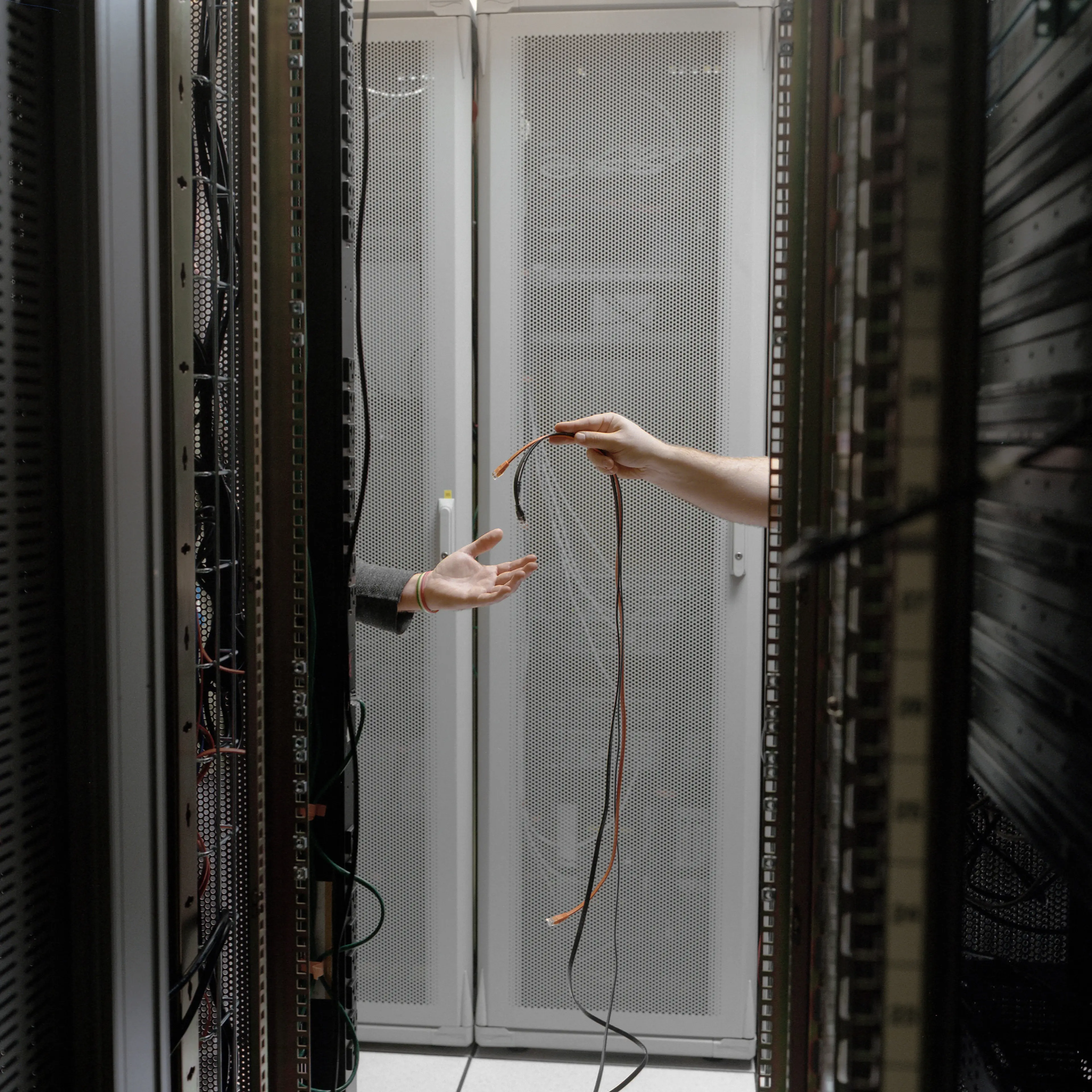 Workers replace cables at a telecommunications hub in New York where companies exchange Internet traffic to boost efficiency.